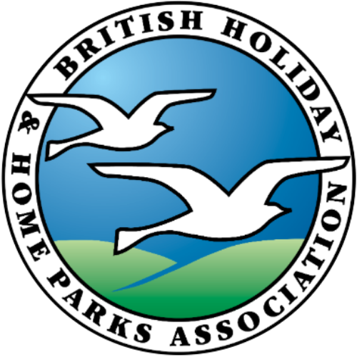 Logo of the British Holiday & Home Parks Association featuring two flying seagulls over green land and blue sky, enclosed in a circular design with black text.
