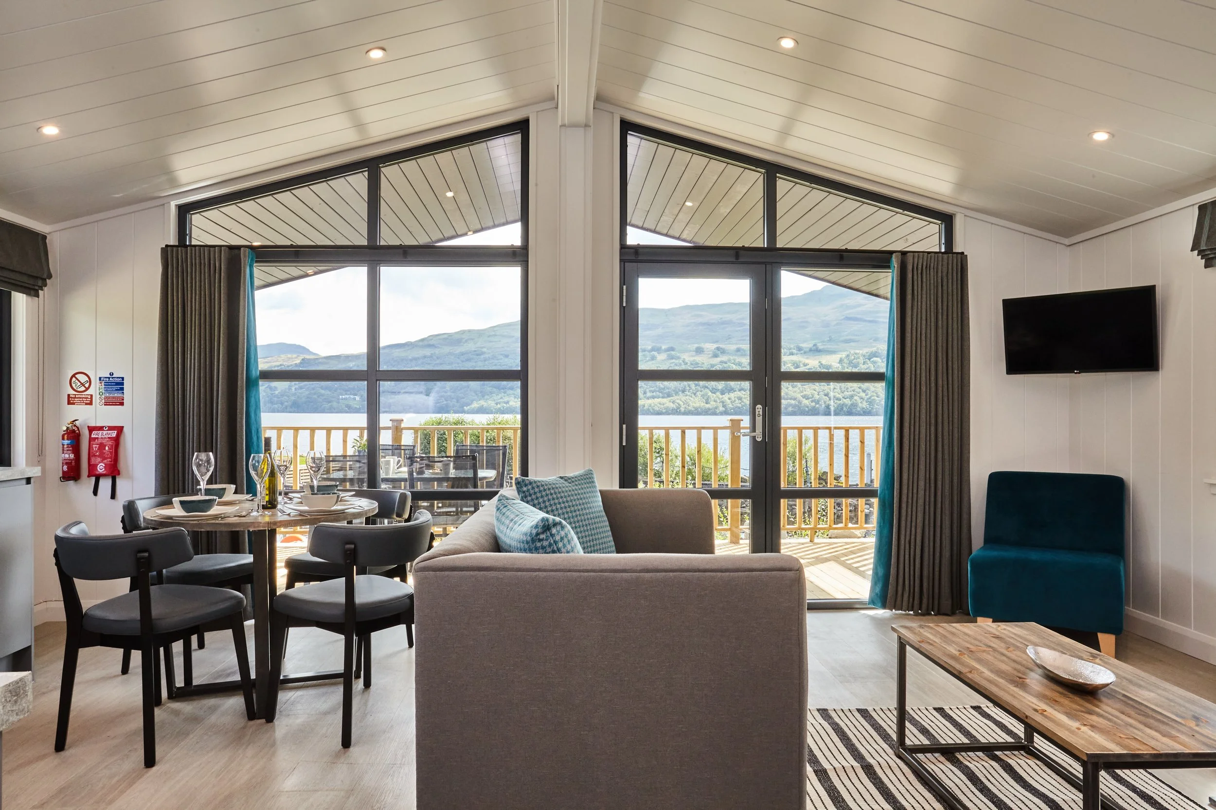 Living room with a dining table, sofa, and a balcony with mountain view