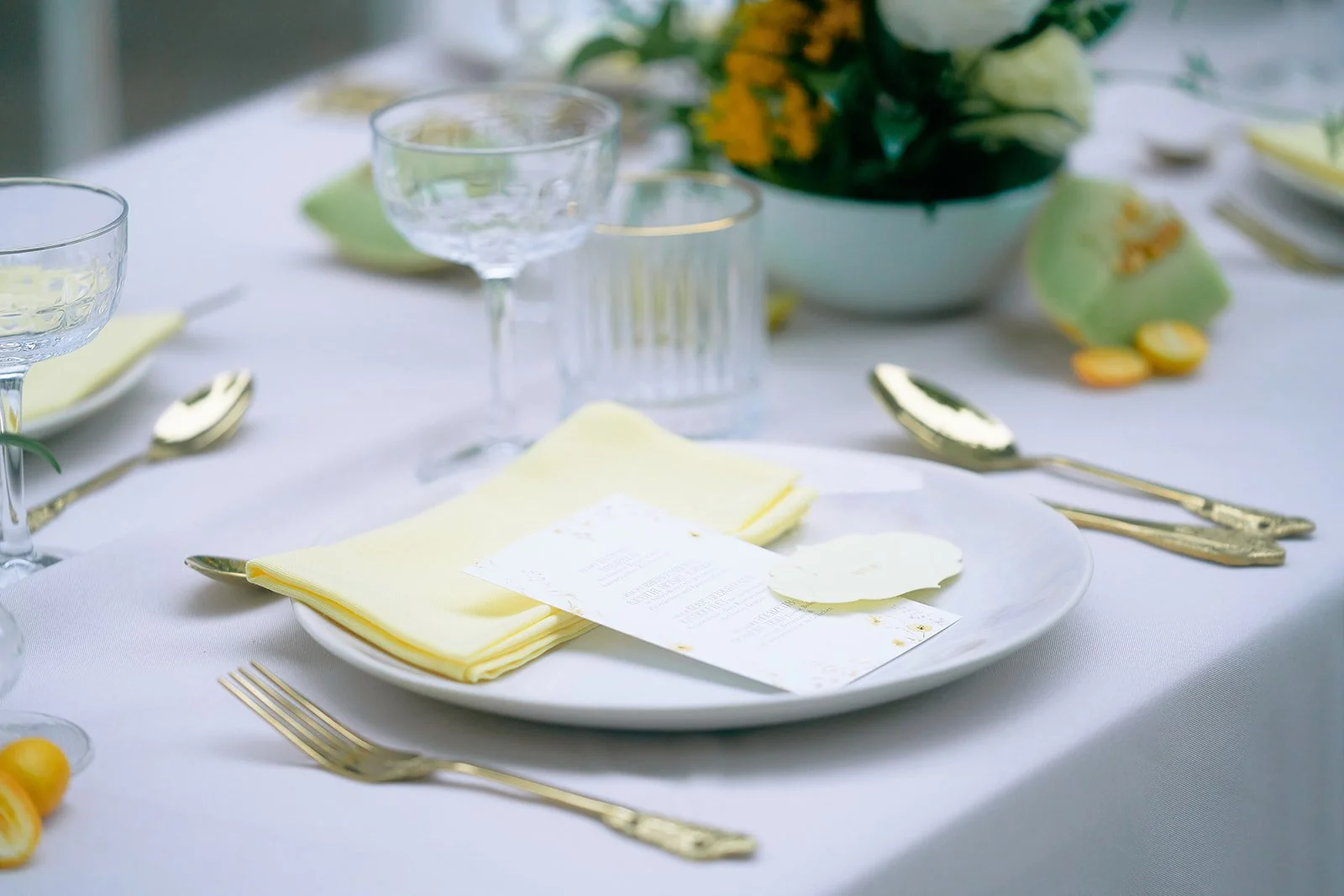 Blume in cremigen und roten Farbtönen auf einem festlich gedeckten Tisch