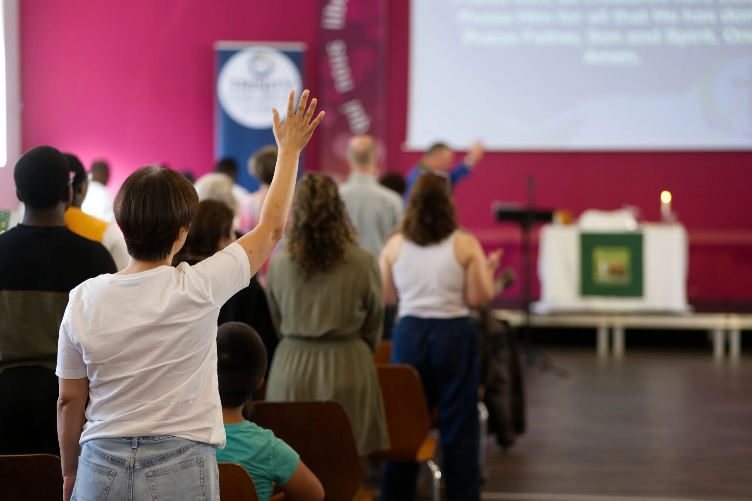 Congregation singing with one member having their arm raised
