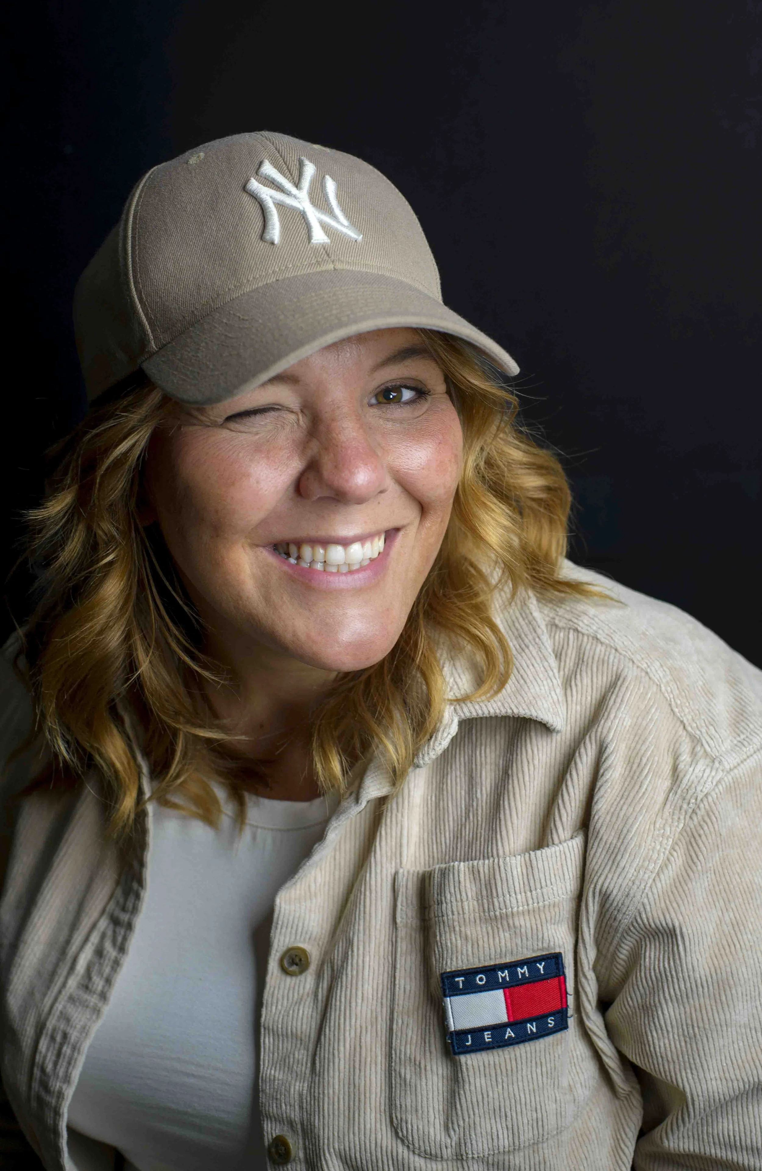 Female leader winking with her New York yankees hat on