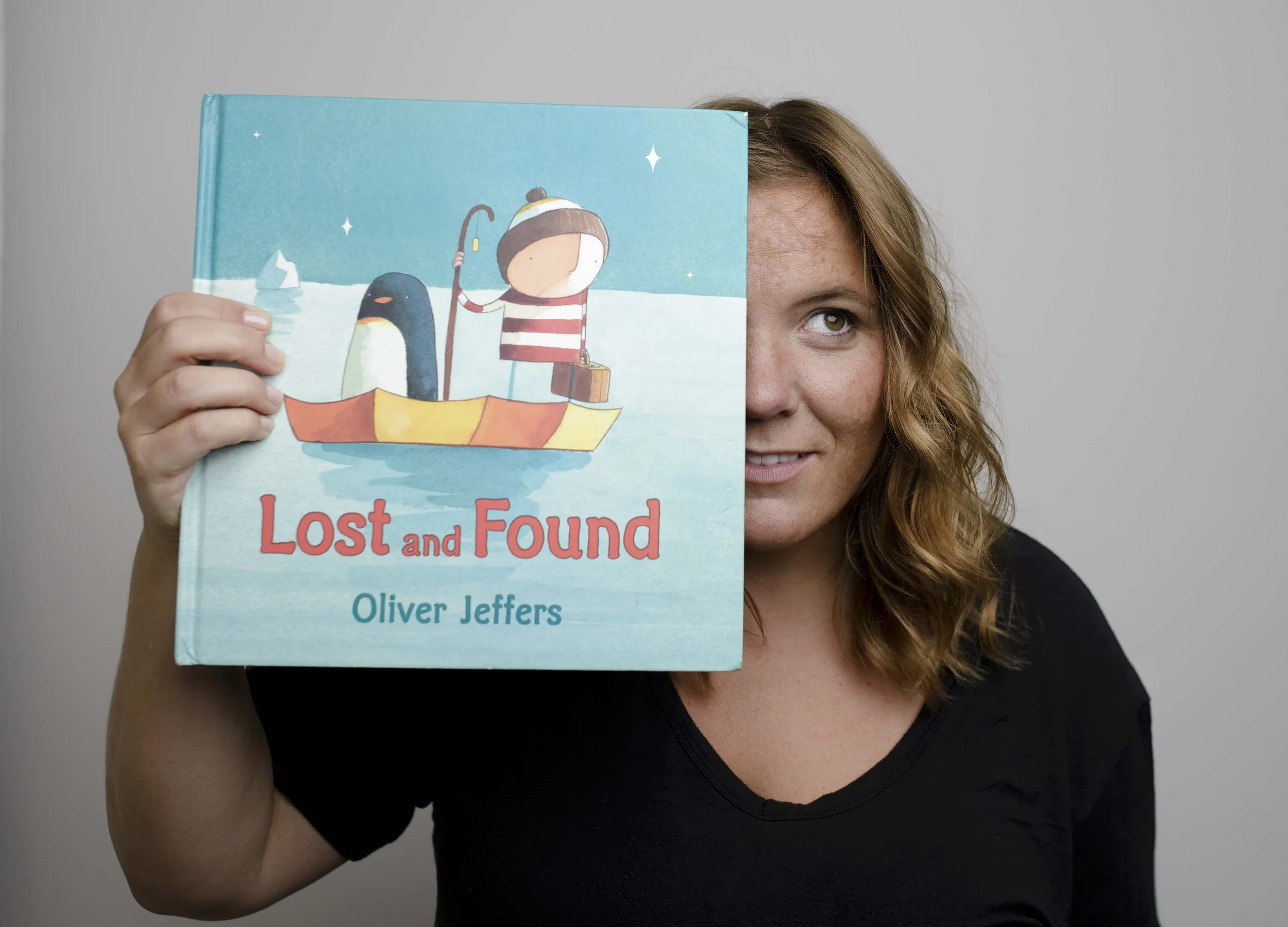 female leader posing with lost and found children's book