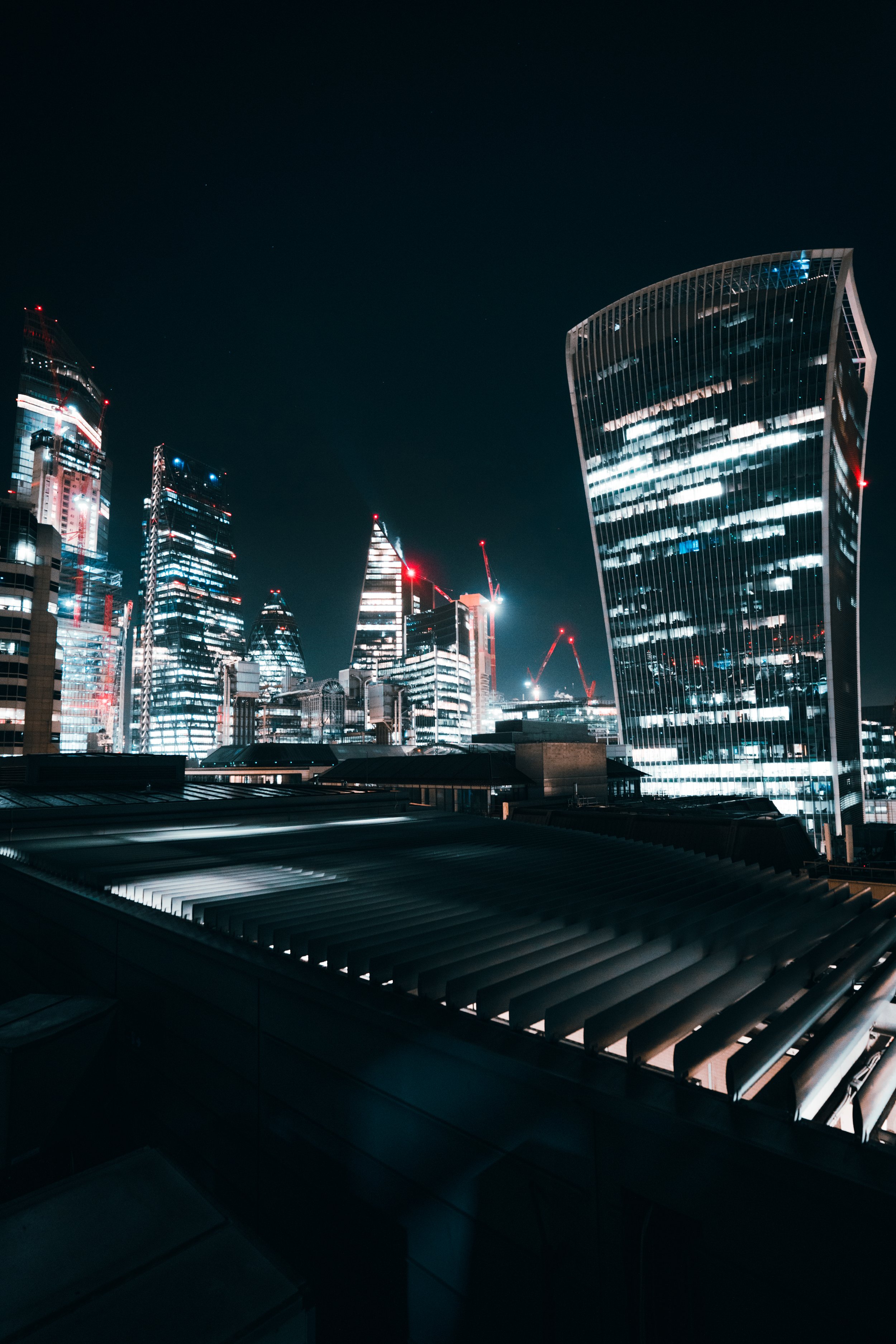 Nighttime cityscape with illuminated skyscrapers and modern buildings in a financial district