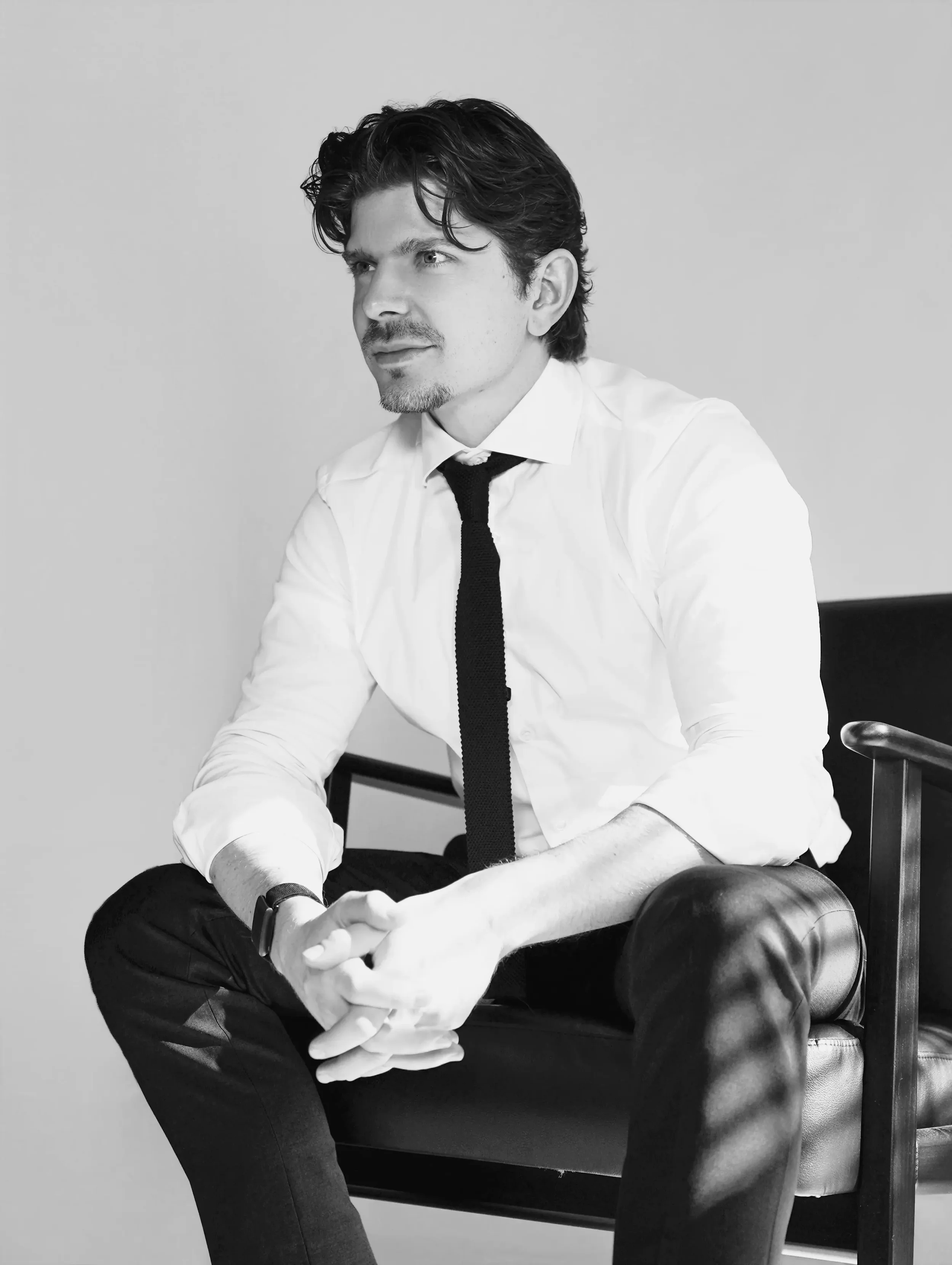 Close-up black and white portrait of man in white shirt and tie looking aside, individual portrait photography New Moon Agency Klagenfurt