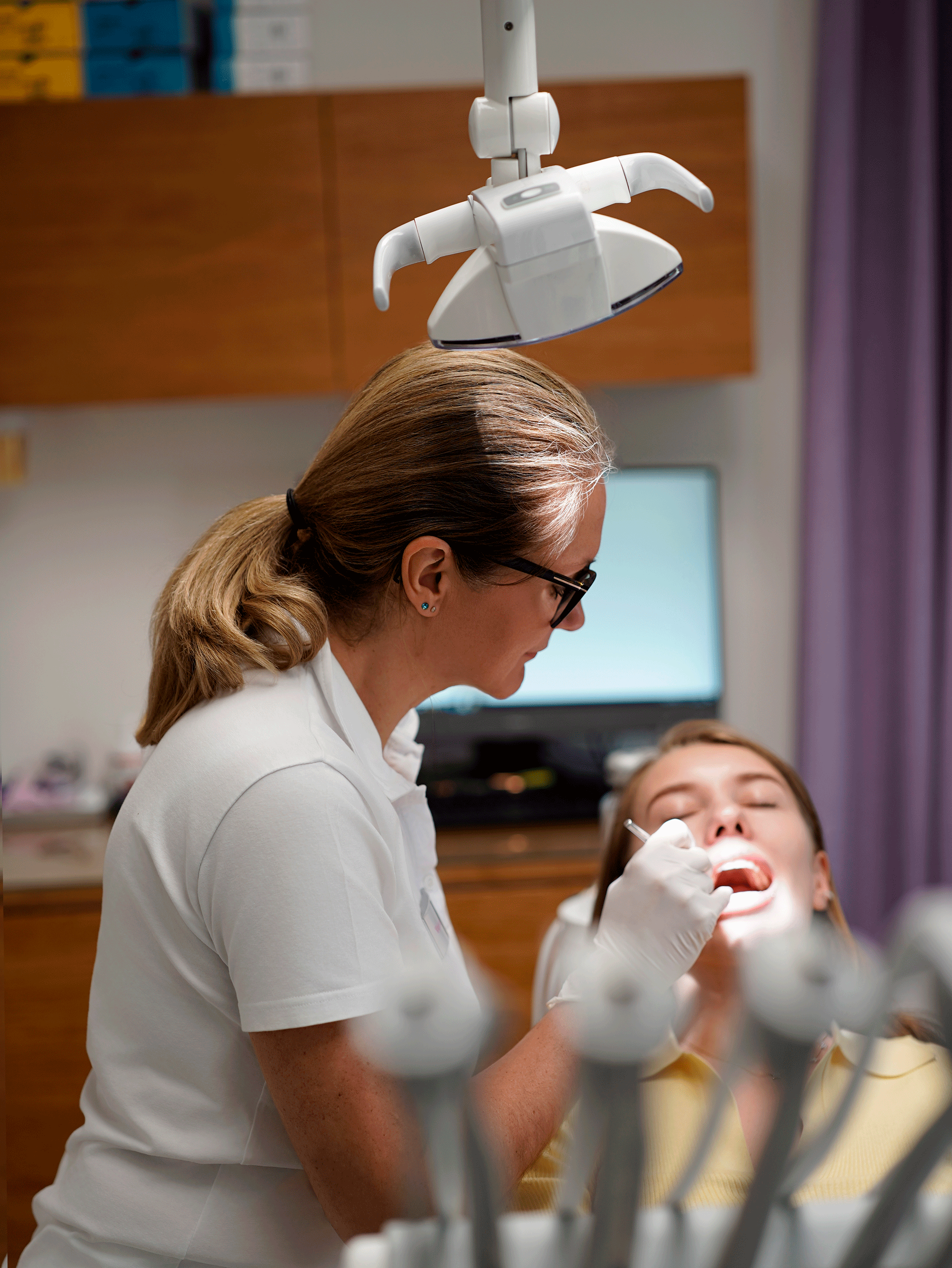 Dental assistant treating patient, clinic photography New Moon Agency Klagenfurt