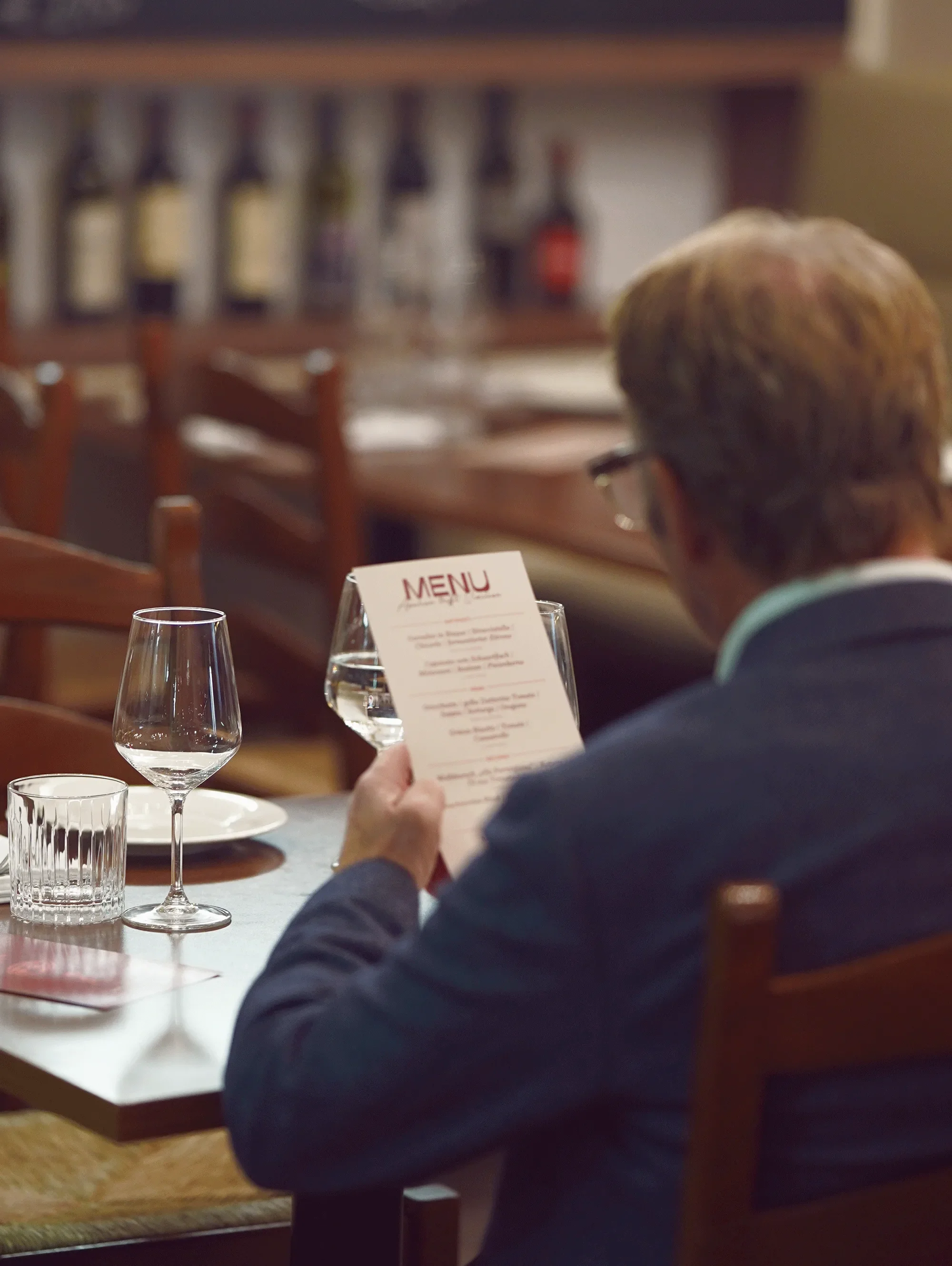 Guest reading menu in restaurant interior — restaurant photography New Moon Agency Klagenfurt