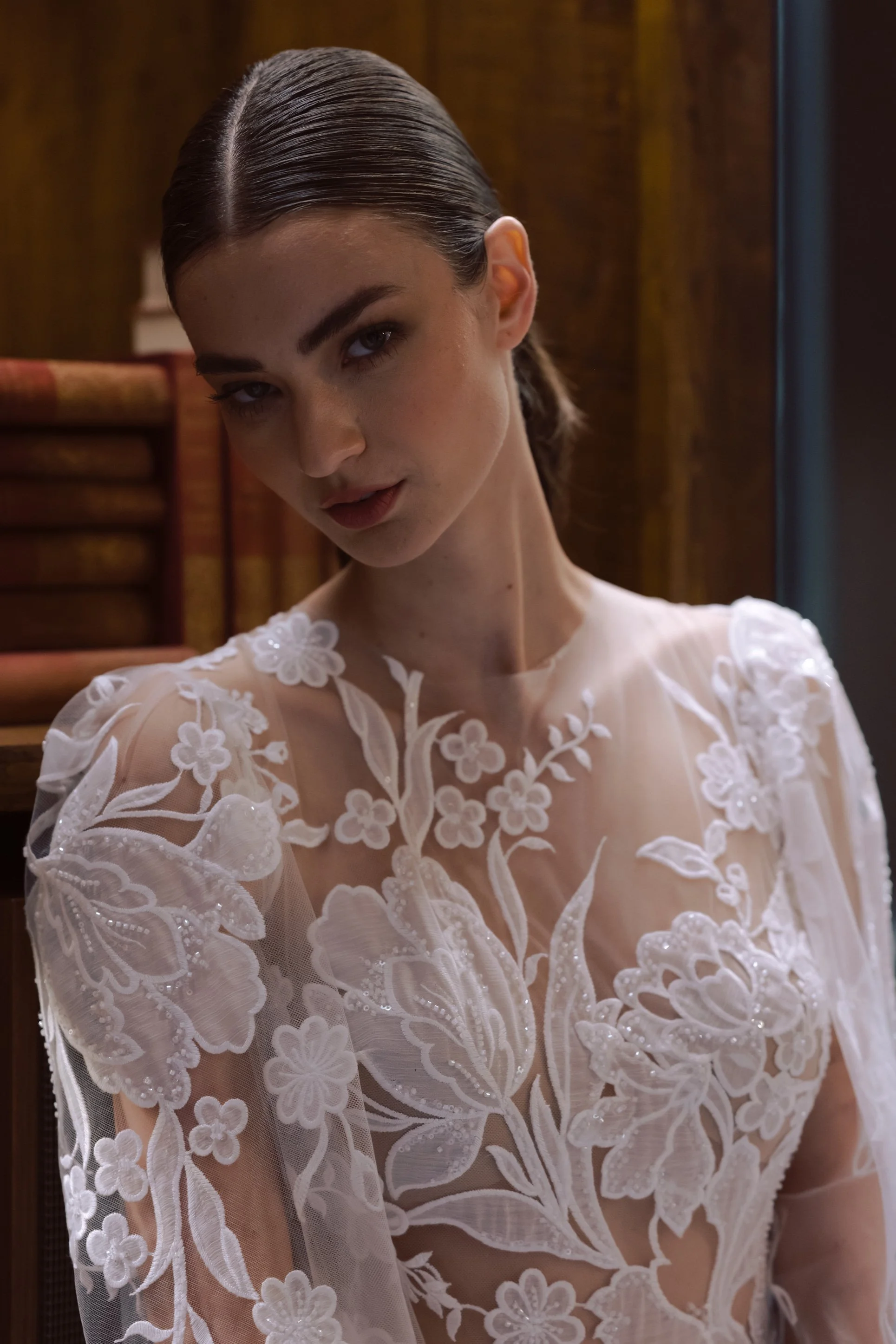 Bride with natural waves in floral lace gown – refined elegance in soft tones.