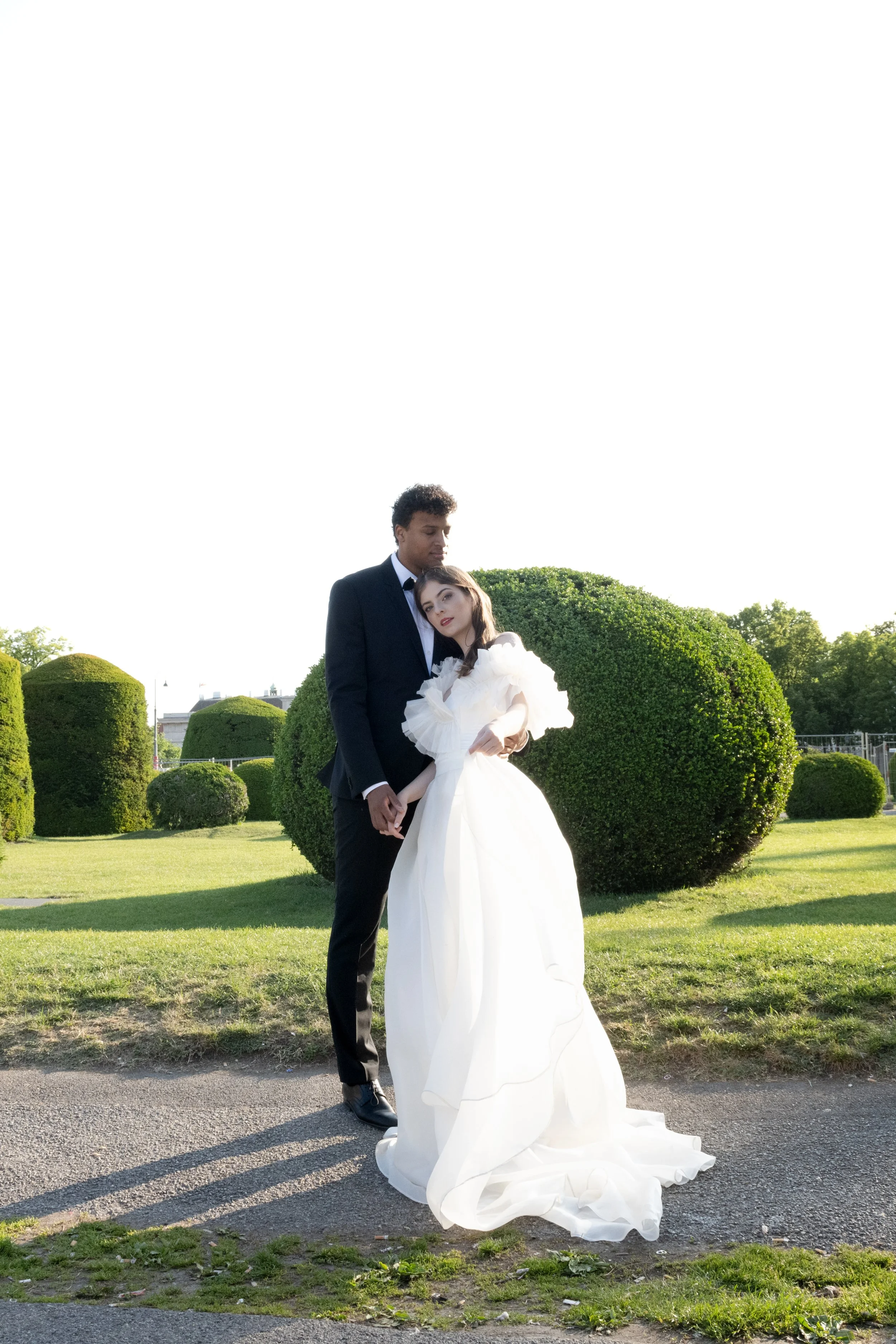 Couple in symmetrical garden setting – classic fine art portrait with sculptural greenery. fine art wedding photography