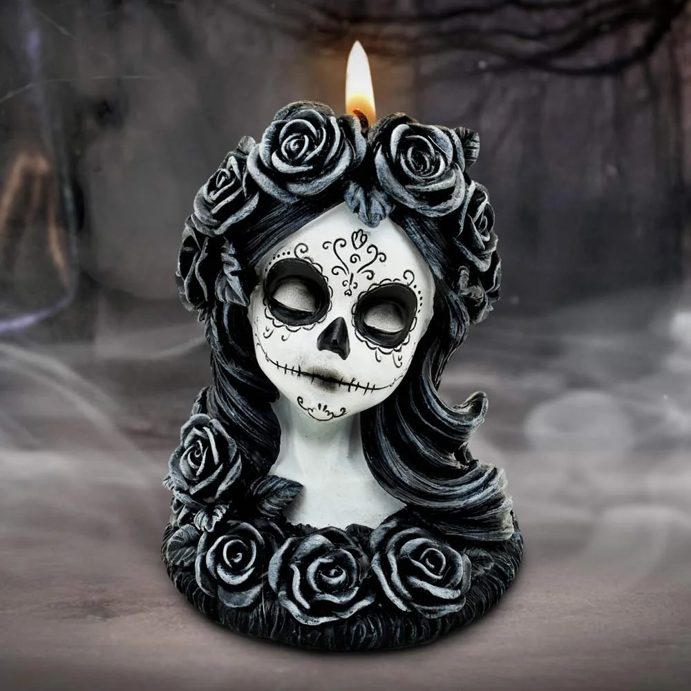Decorative skull candle with black roses and a flame on top, styled in the sugar skull tradition for Day of the Dead.