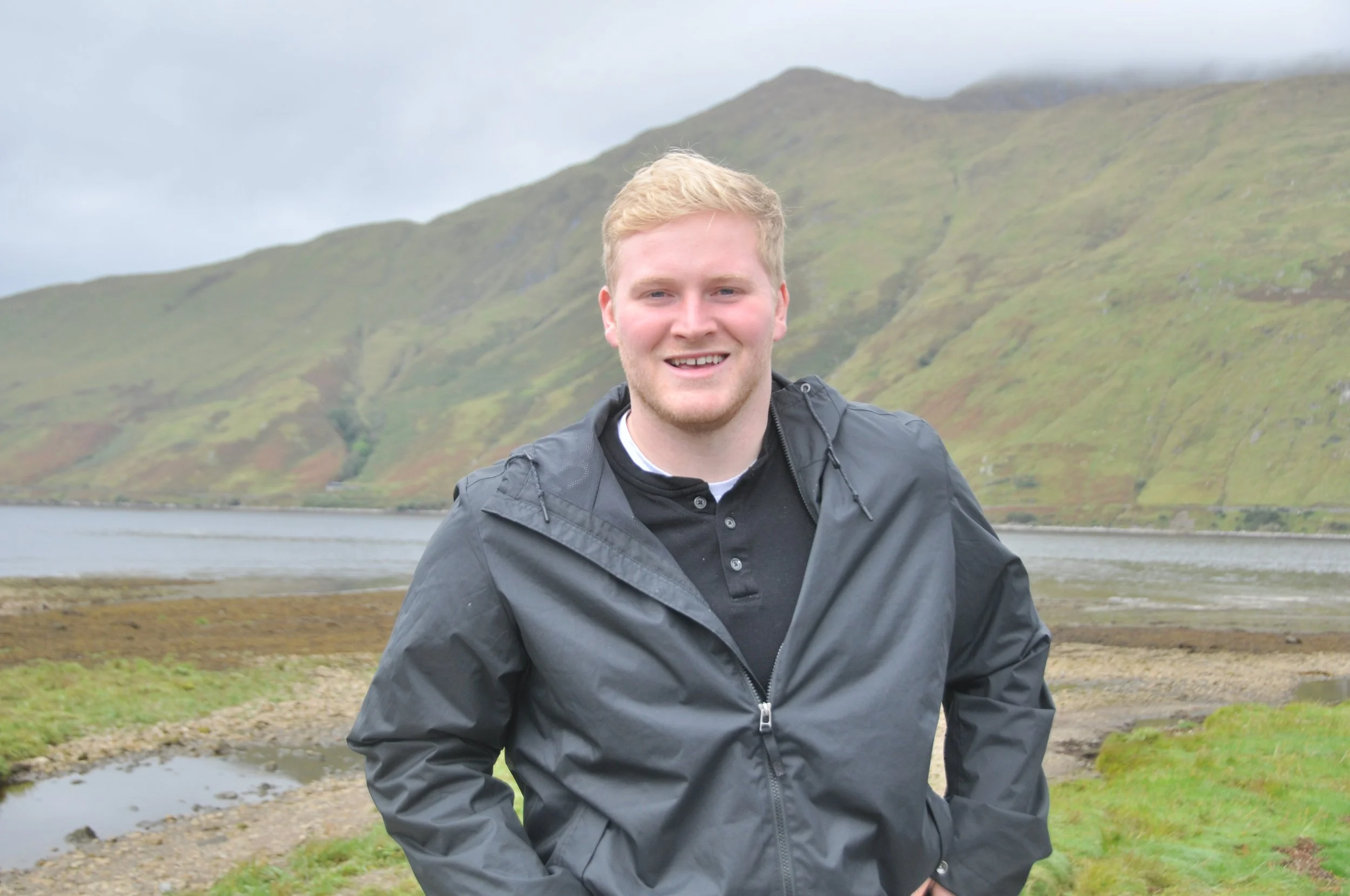 Portrait of Brendan Baggett, professional Boston photographer, outdoors near scenic hills