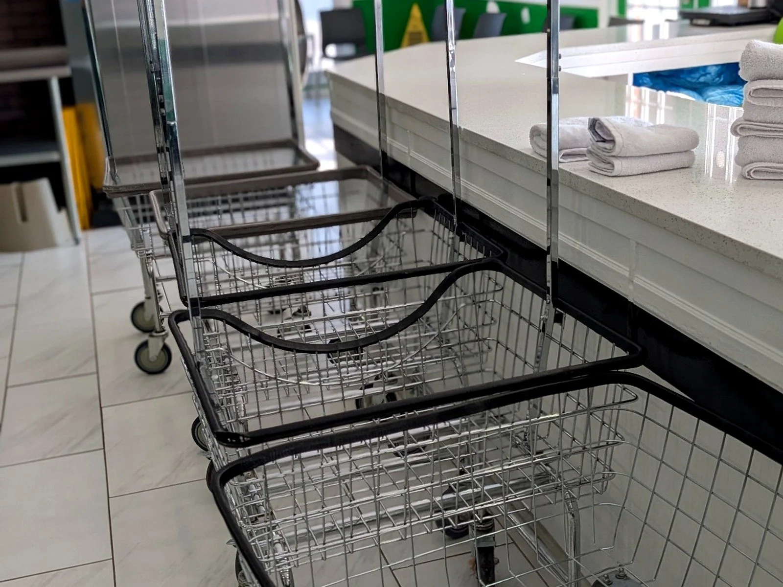 Laundry carts lined beside the spacious folding counter inside WSHFLD Laundry.