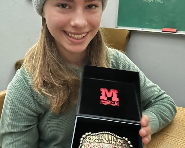 student holding buckle from rodeo competition