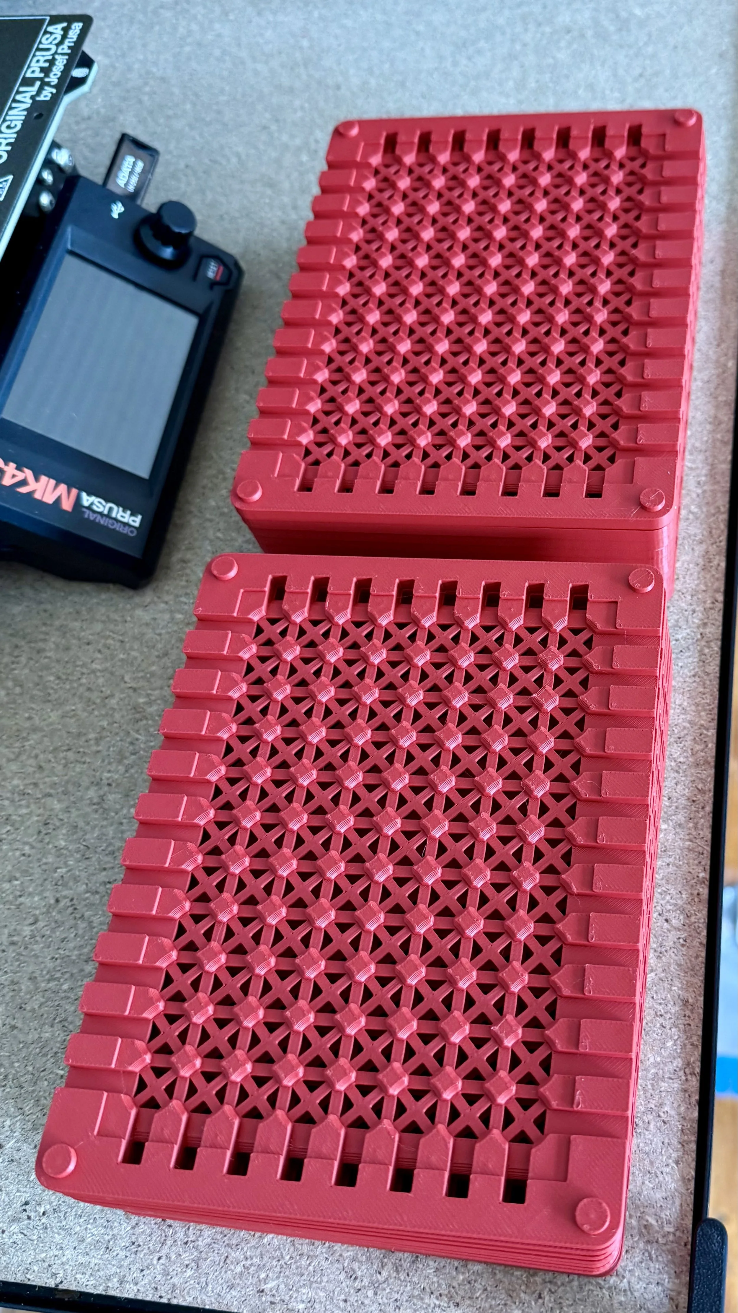 Custom red 3D printed plates with Prusa Printer in background.