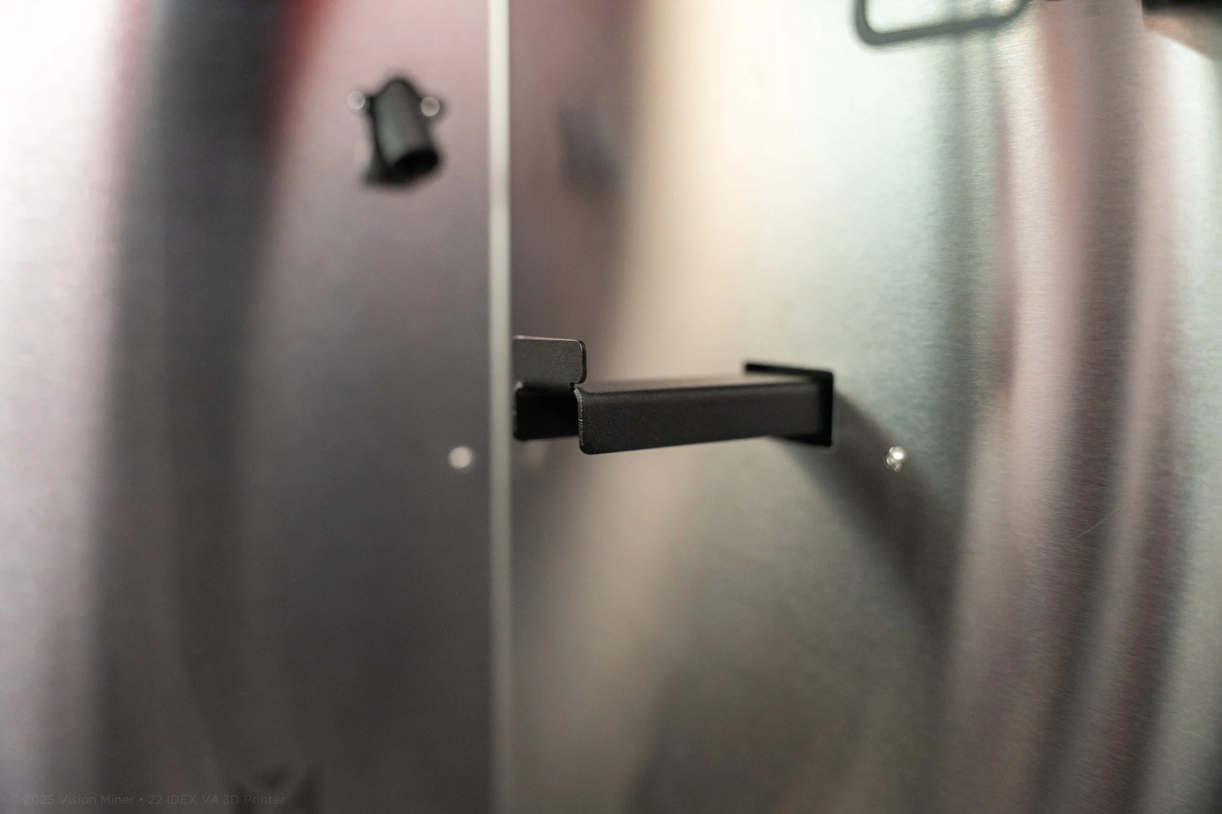 Close-up of a printer with a metallic surface and a black paper tray indentation.