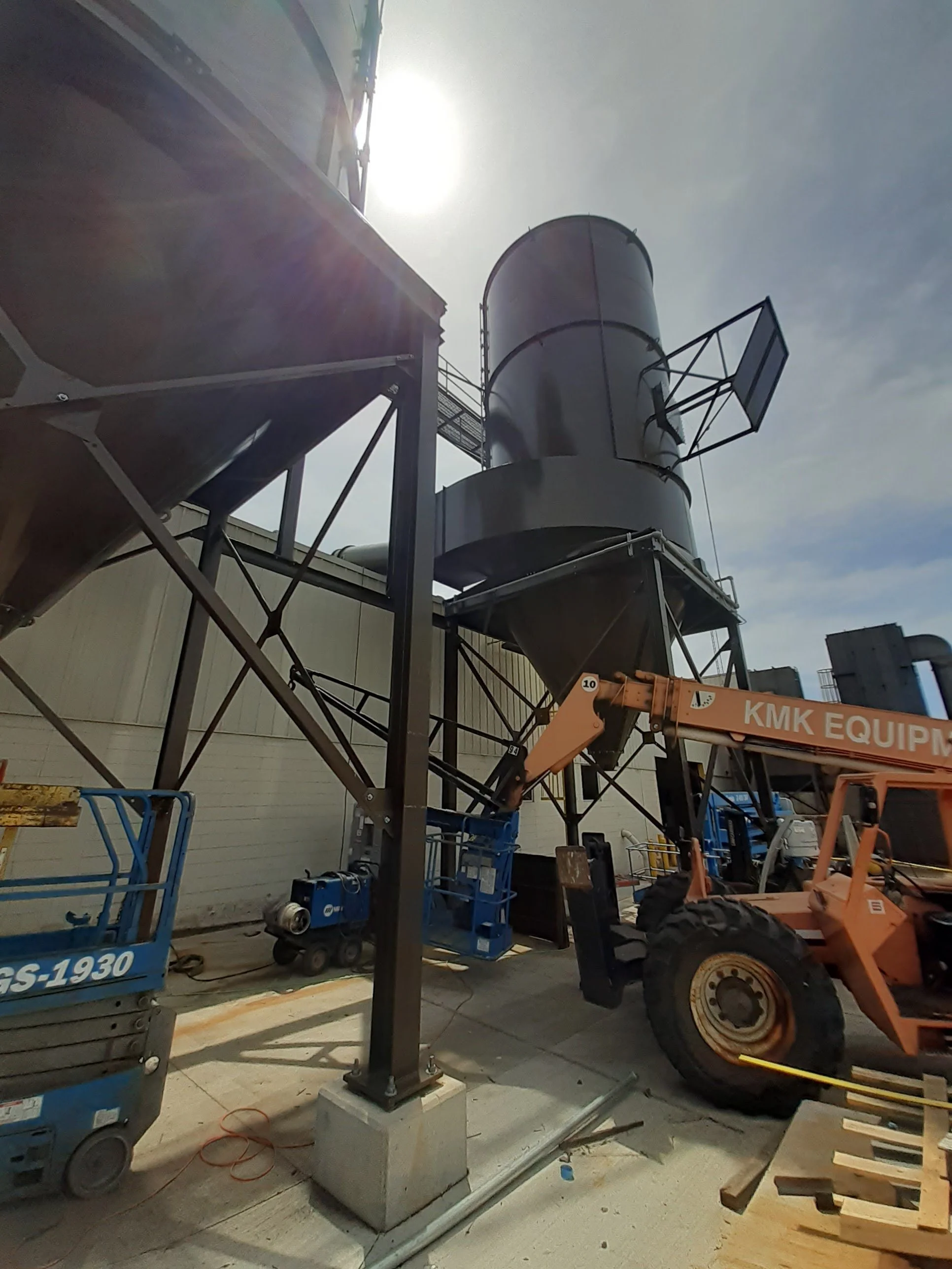 Dustar Unit, including a telescopic lift and a forklift, near a building under construction.