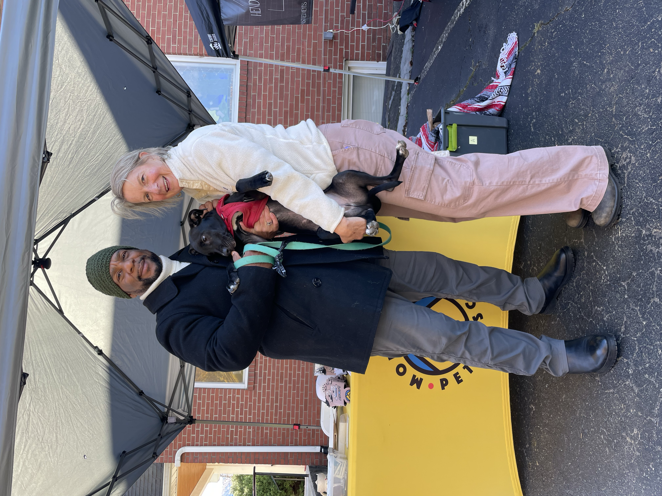 Board president, Justice Rogers, and his wife pose with their newly adopted dog from Mountain Pet Rescue at the Swannanoa Farmers Market. 