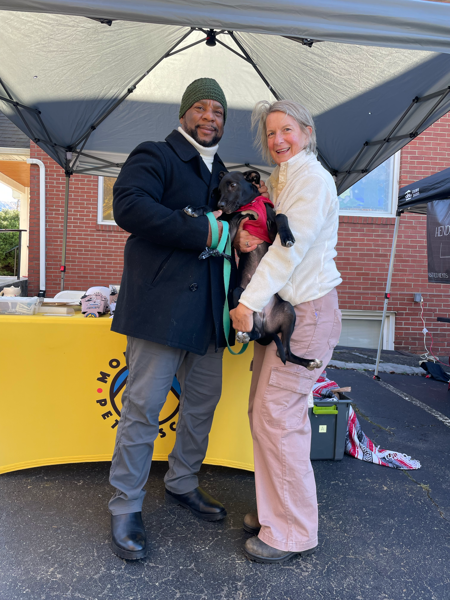 Board president, Justice Rogers, and his wife pose with their newly adopted dog from Mountain Pet Rescue at the Swannanoa Farmers Market. 