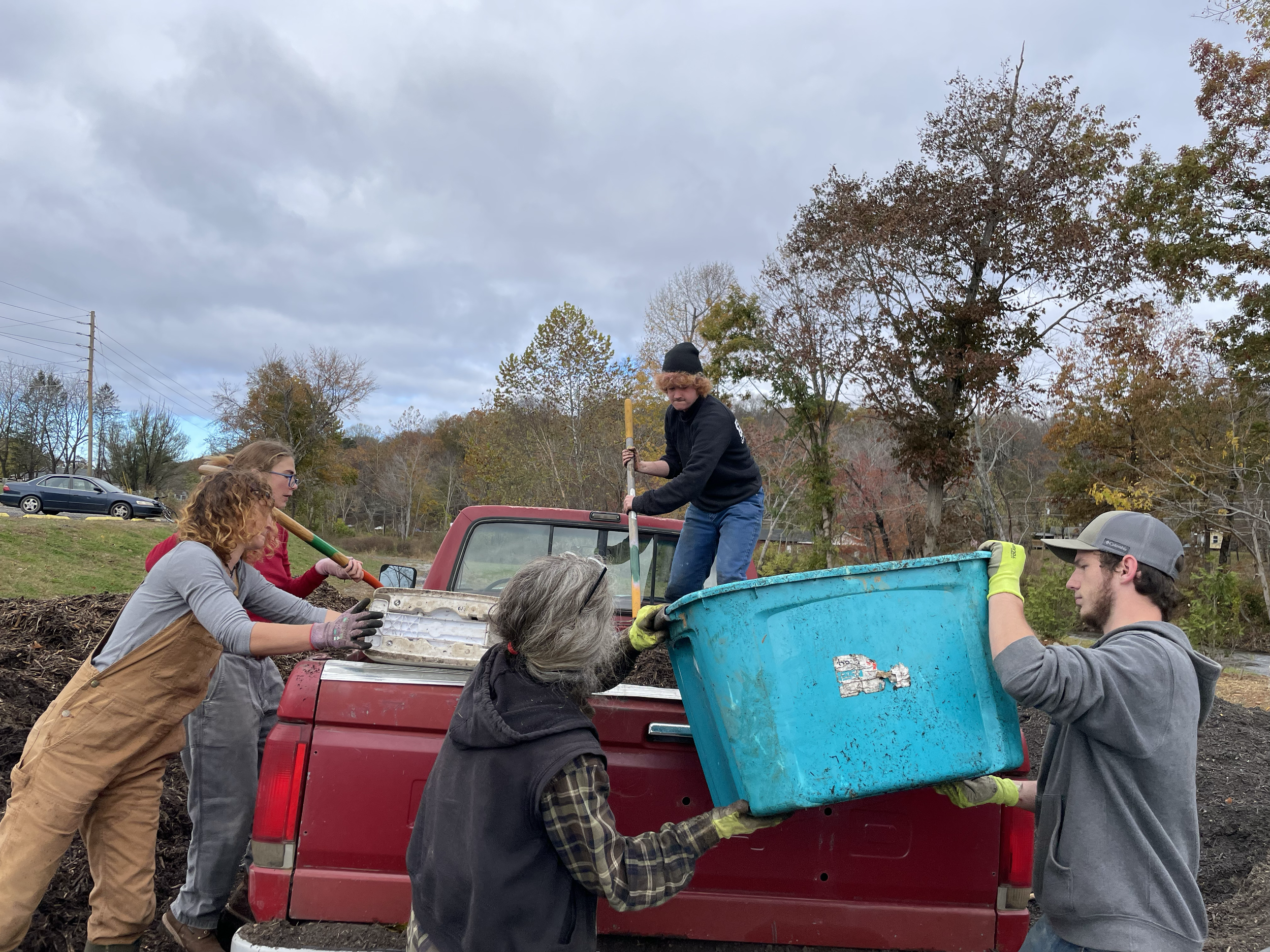 Warren Wilson students and community member, Cathy Hubbell, loading up donated mulch from the Blessing Project to add to our community garden. 