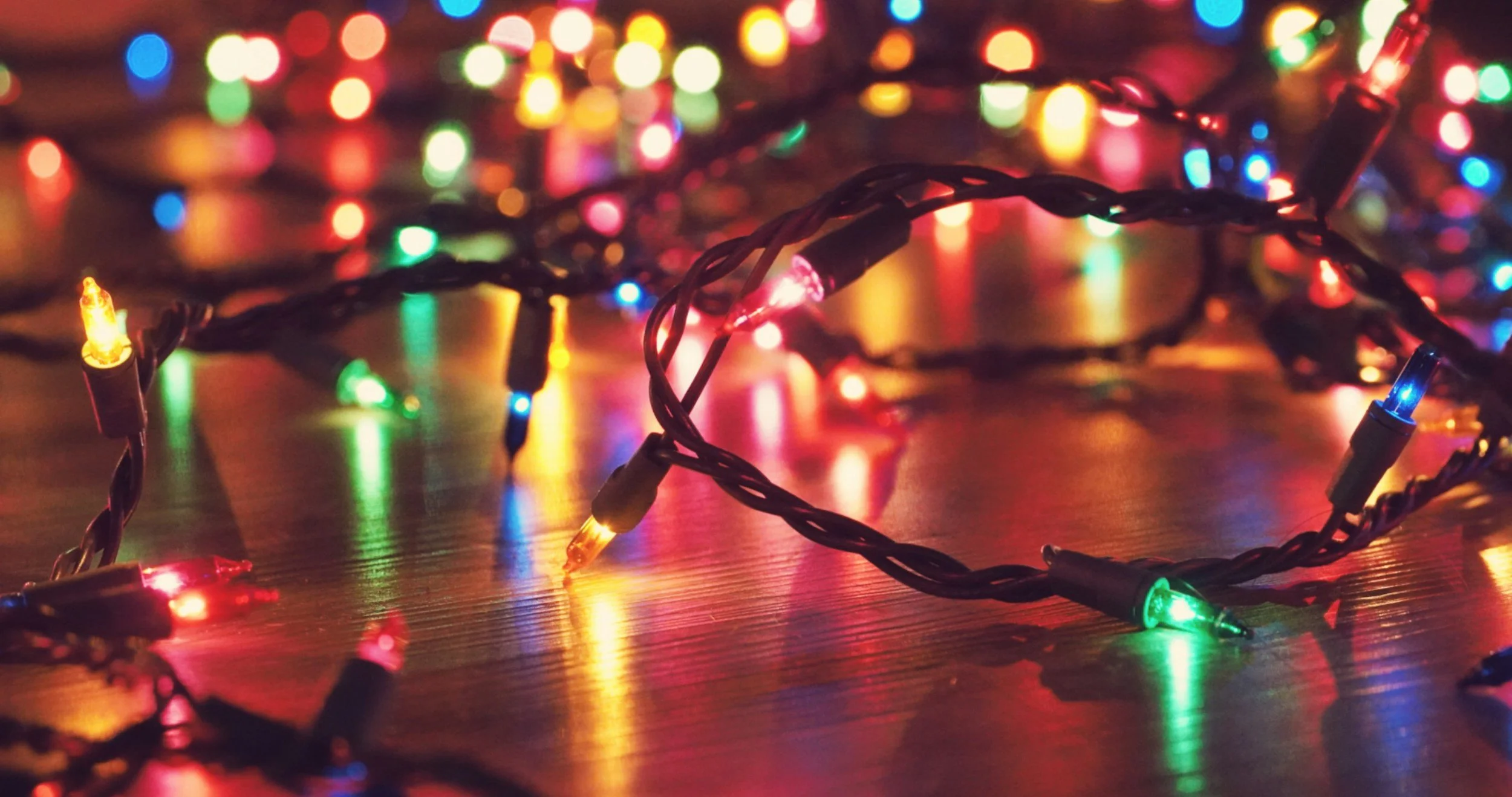 Colorful Christmas lights on the floor symbolizing the messy, overwhelming parts of the holiday season for moms.