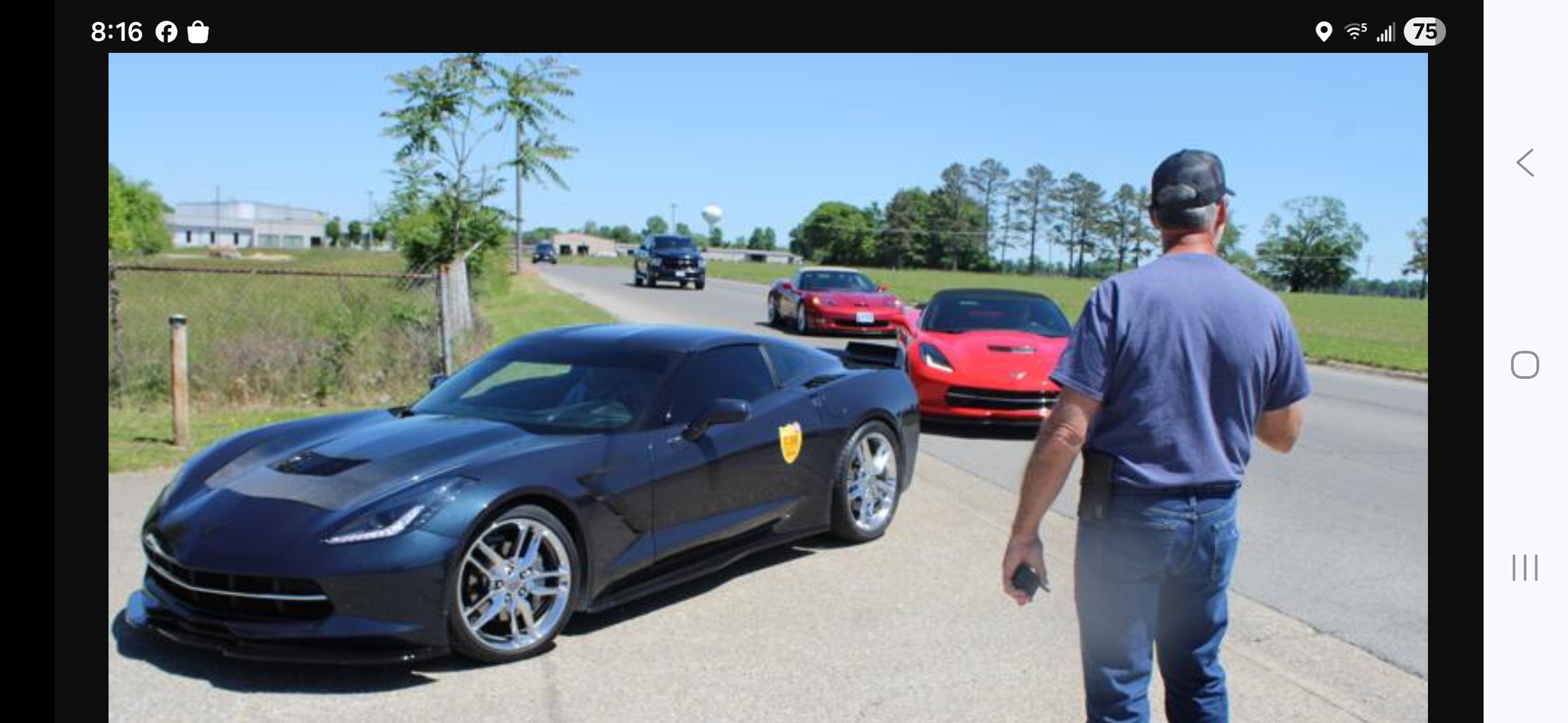 Club member directs Corvettes arriving.