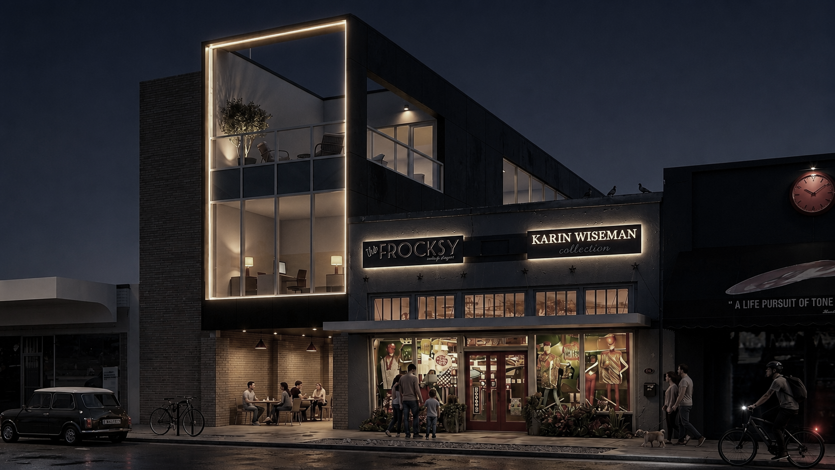 Night view of a commercial building with illuminated signs, featuring clothing displays inside, outdoor seating with people, parked car, bicycles, and pedestrians including a person riding a bike and walking a dog.