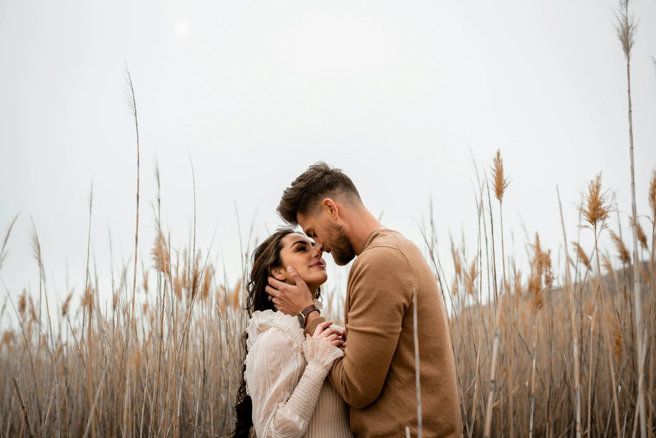 a young couple embracing in an outdoor field