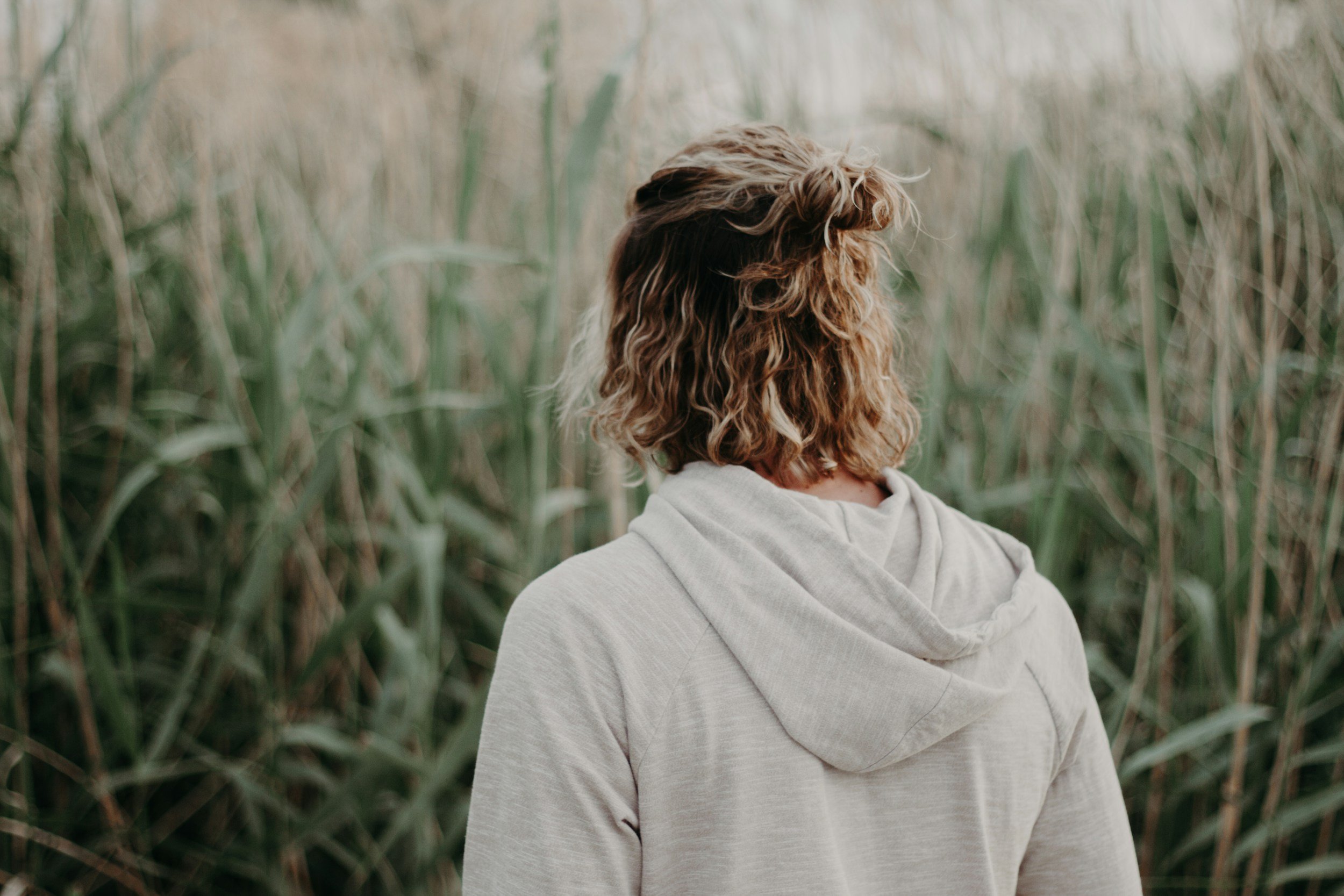 Young Man in Field with Back Turned