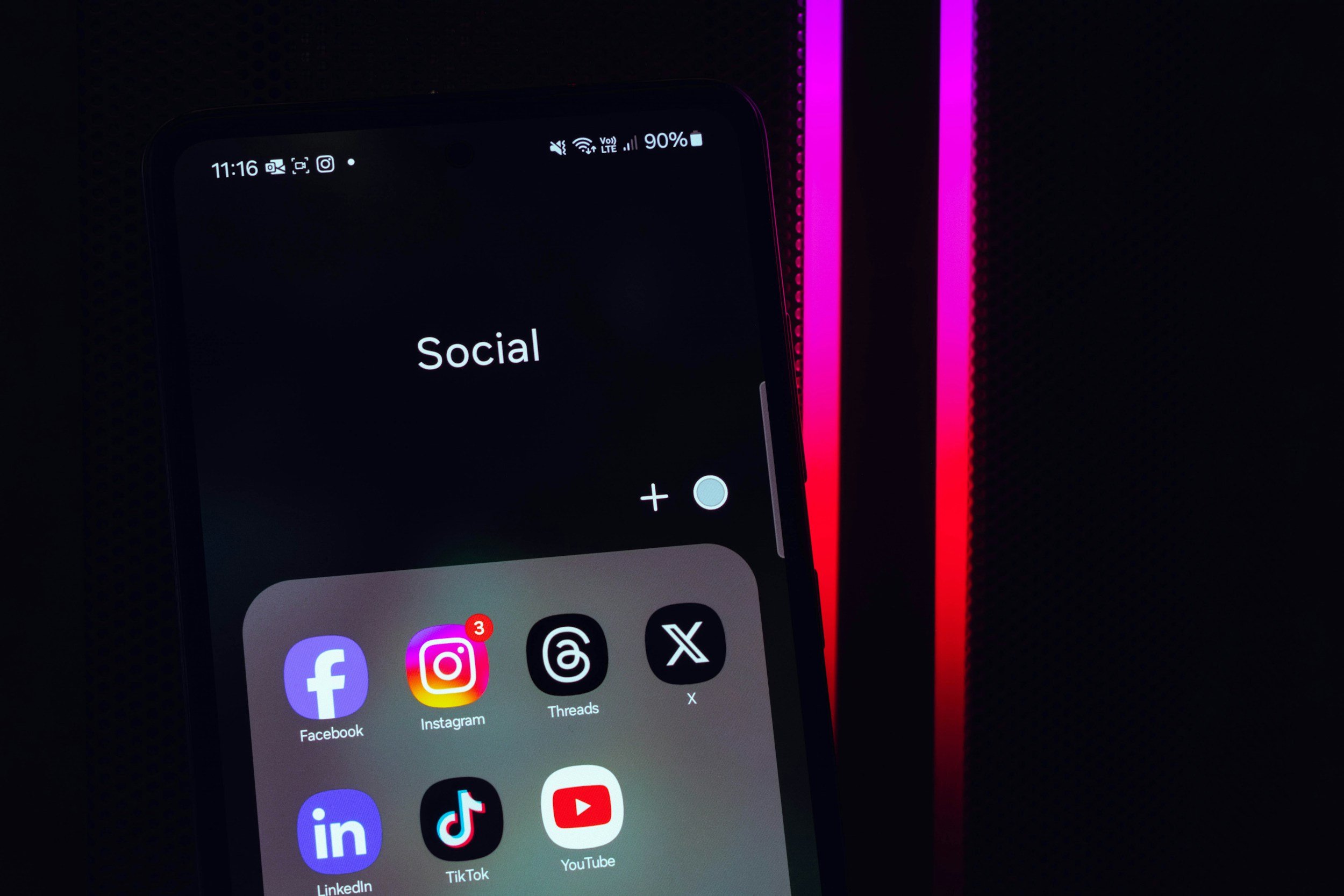 image of social media icons on phone against black background