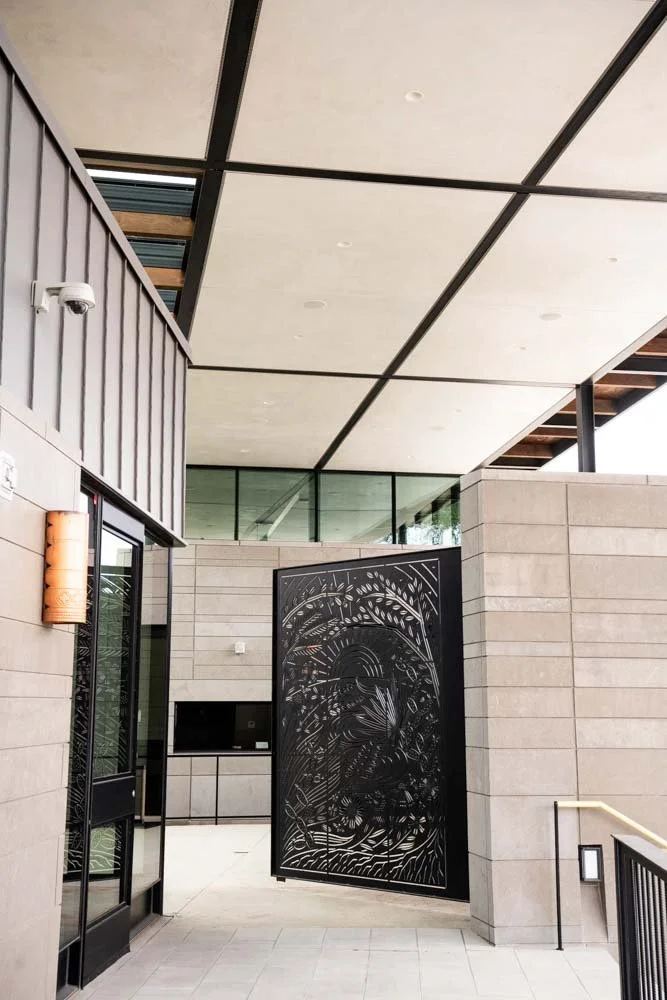 Modern building entrance with decorative metal gate and security camera.