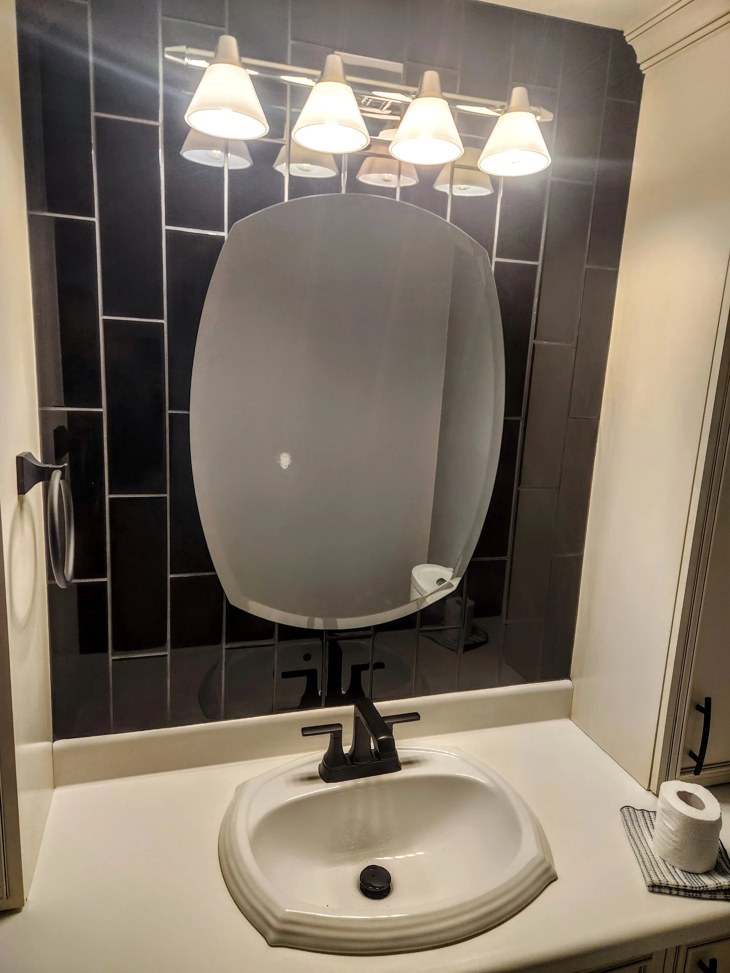 Bathroom sink with oval mirror