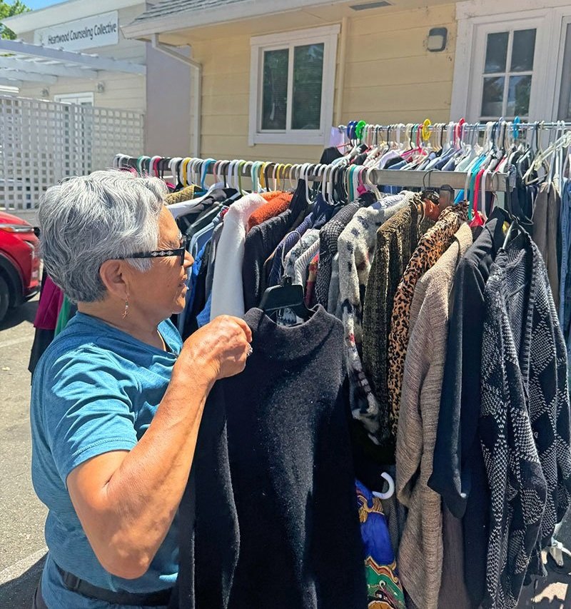 A volunteer arranging clothing on a rack.