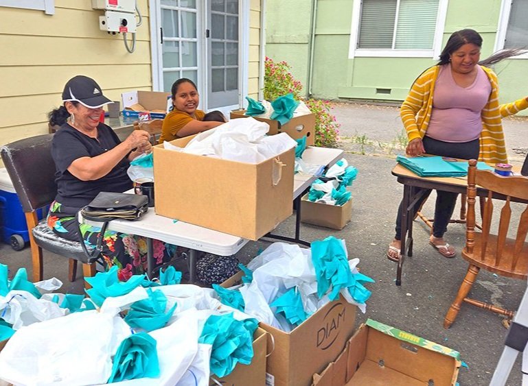 A small group of members preparing gift bags for an event.