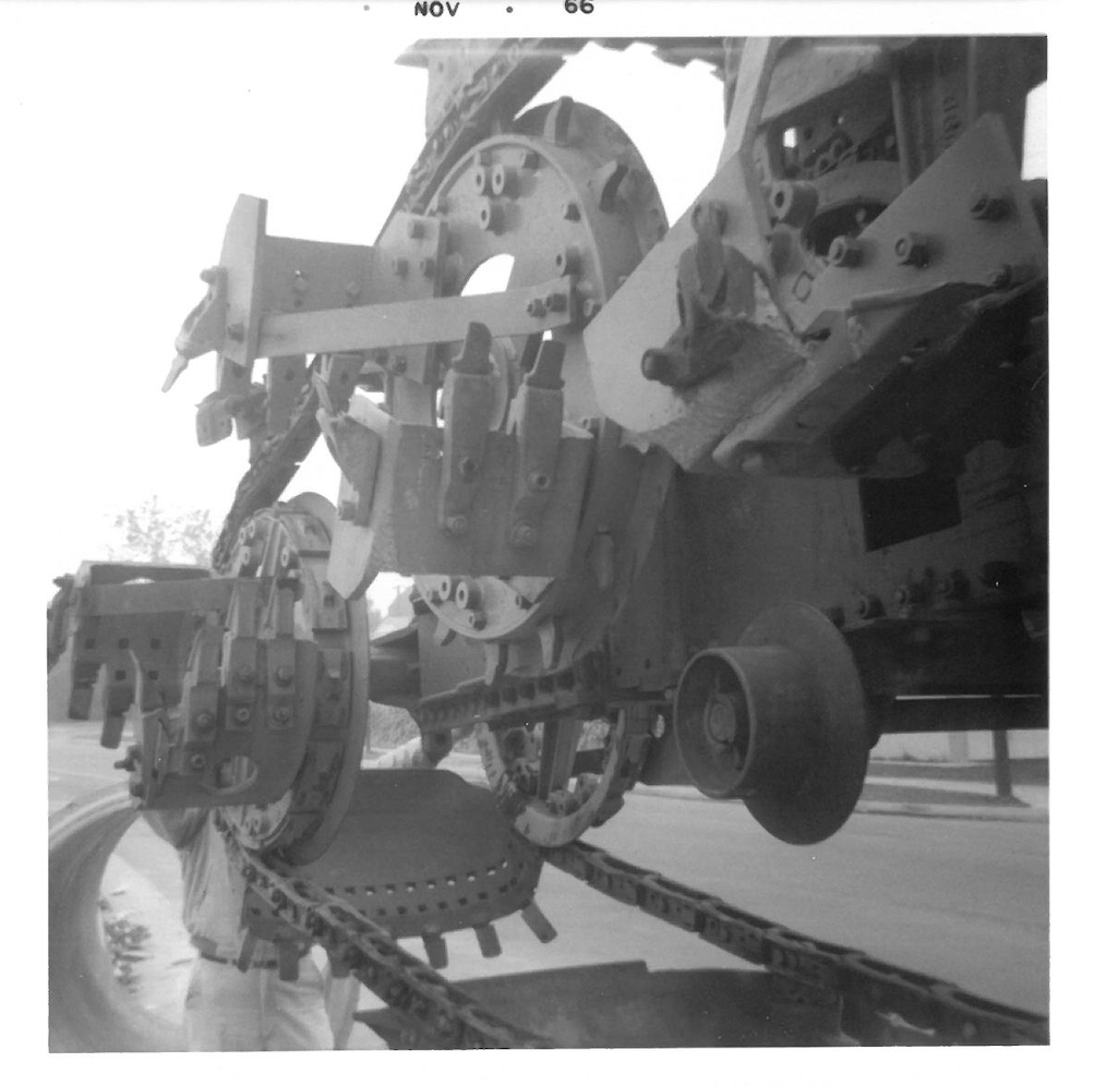 Black and white photo of military artillery machinery or tank parts on a flatbed truck.