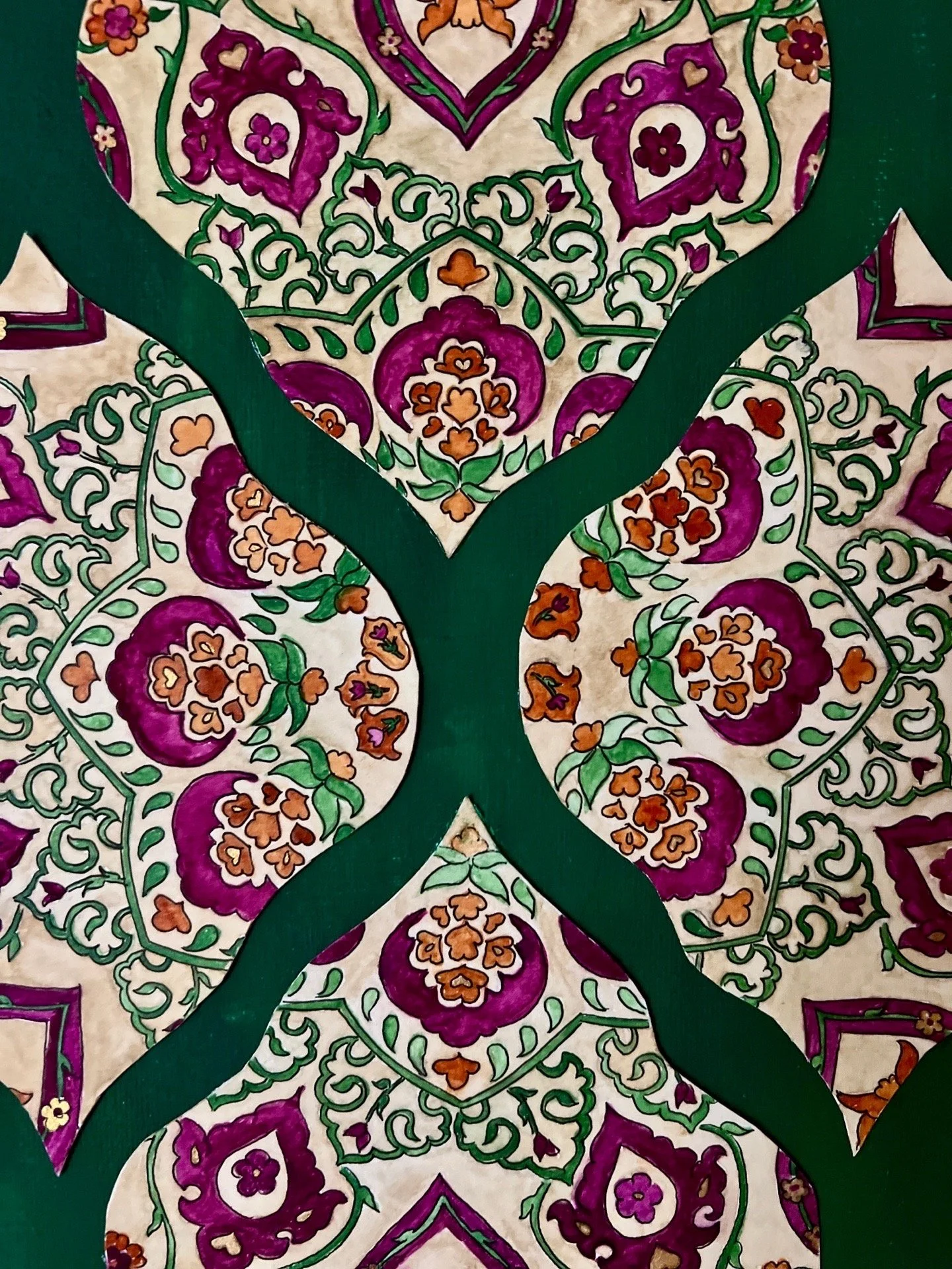 Decorative paper with intricate floral patterns in purple, orange, green, and cream, with green fabric strips creating a cross shape over the design.