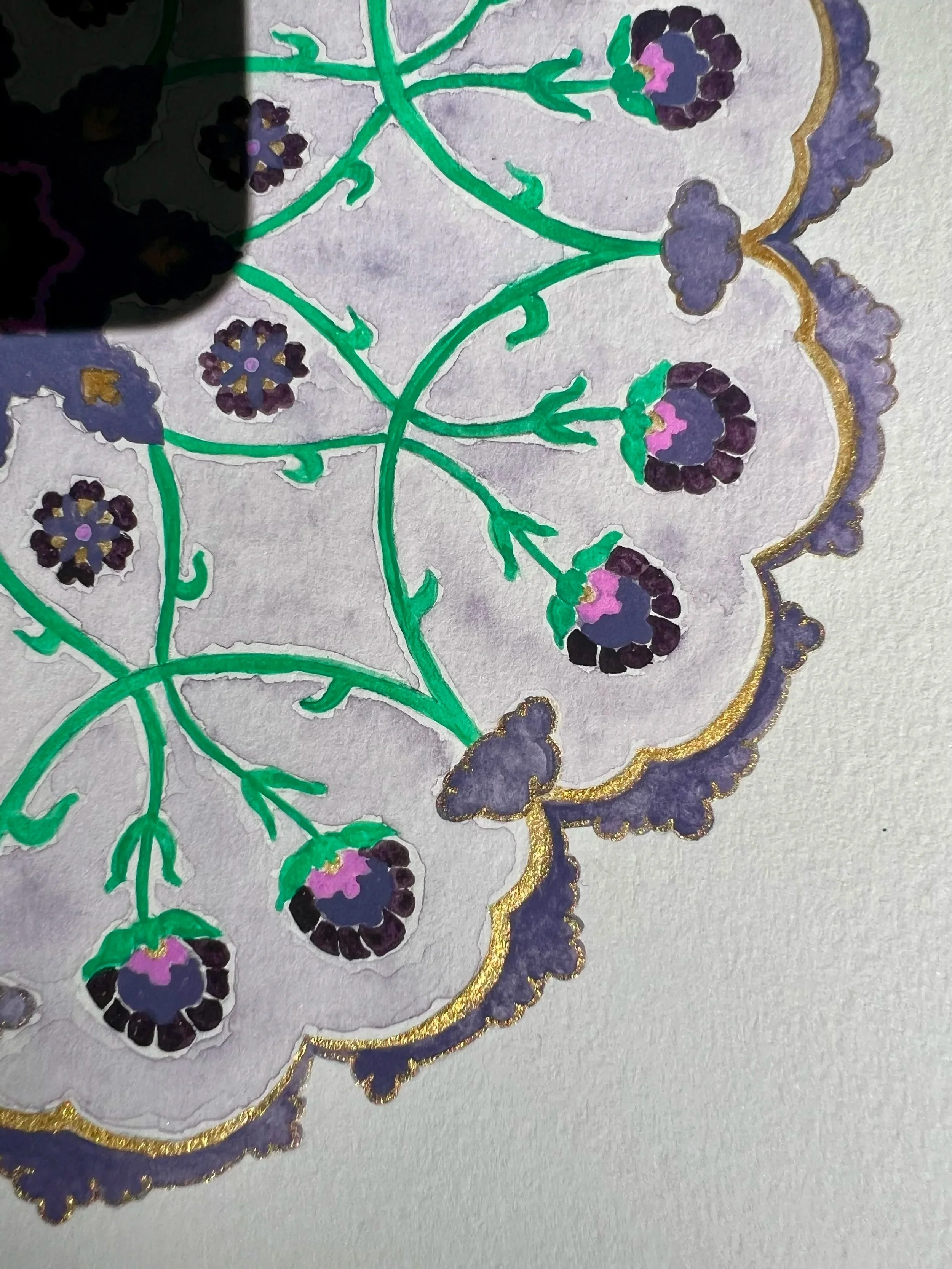 Close-up of an intricate, hand-painted design with purple flowers, green stems, and a scalloped purple and gold border on textured paper.