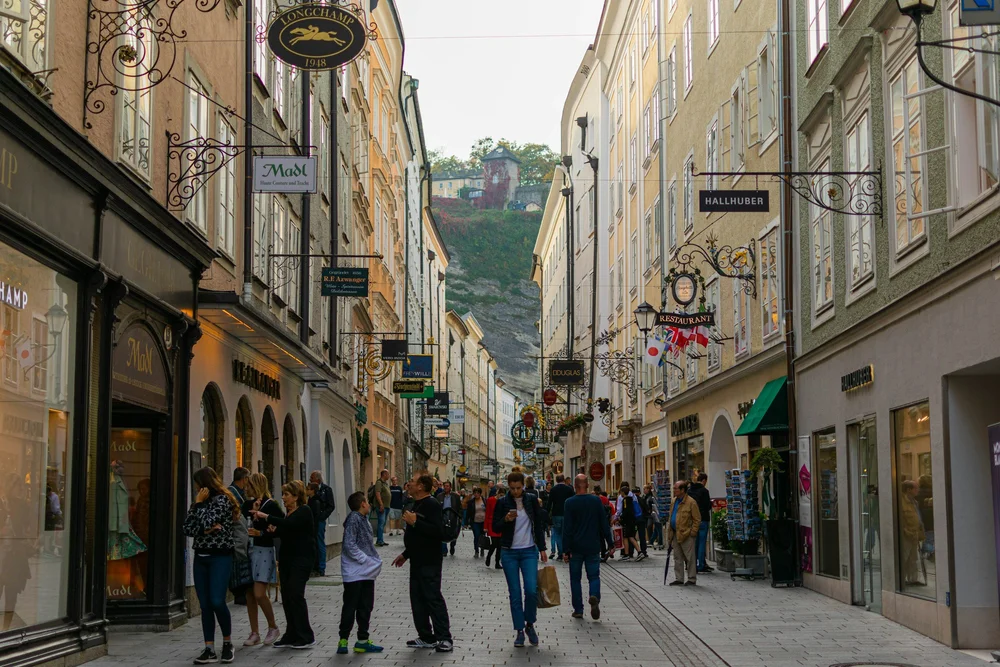 Pedestrians on a historic shopping street in Salzburg.