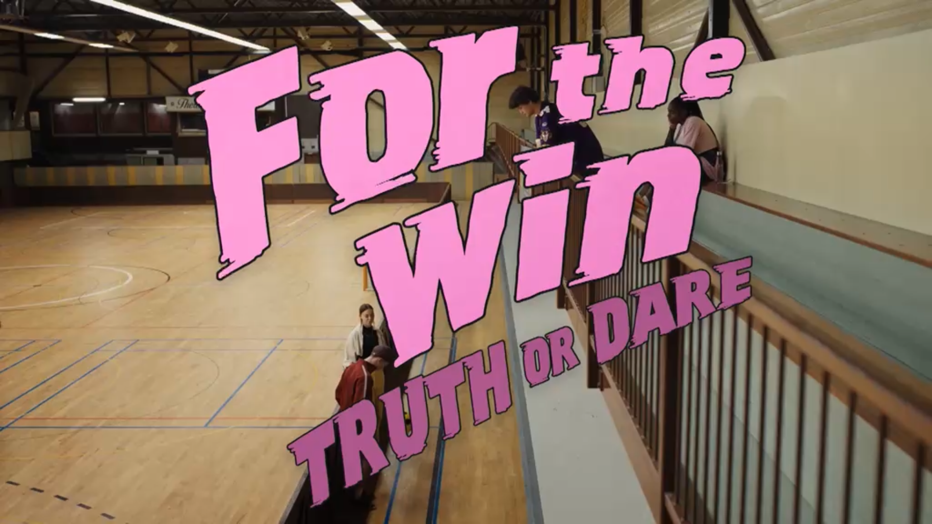 Interior of a gymnasium with a wooden floor, basketball court lines, and a bleacher. Pink text overlay says 'Forte in Truth or Dare'.