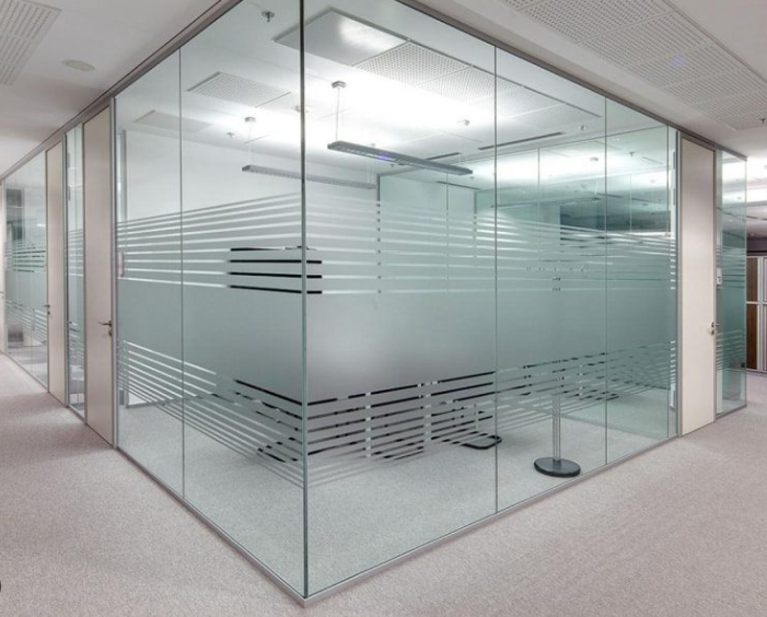 Modern conference room with glass walls, frosted and clear glass sections, inside a corporate office building.