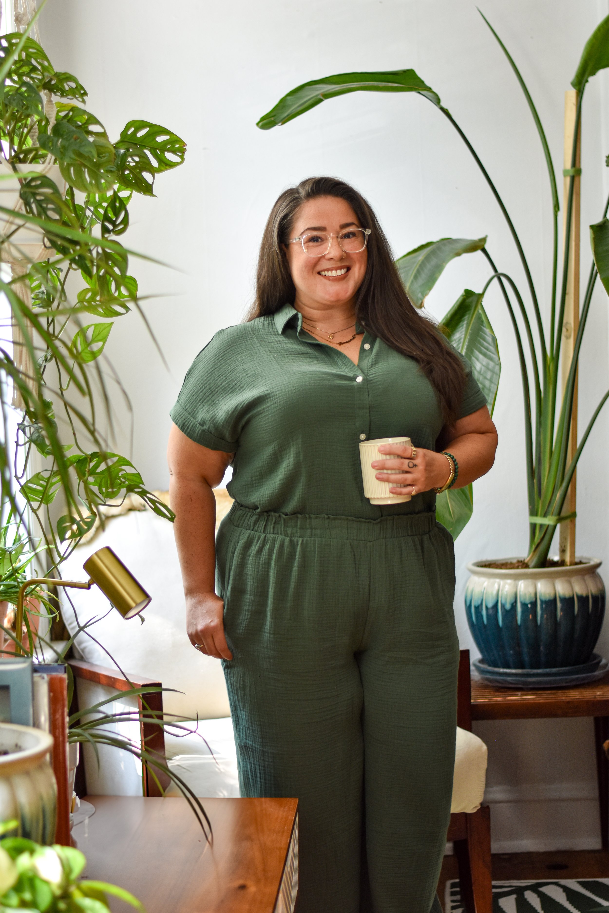 Therapist Savannah Helton standing in front of a chair and holding a coffee
