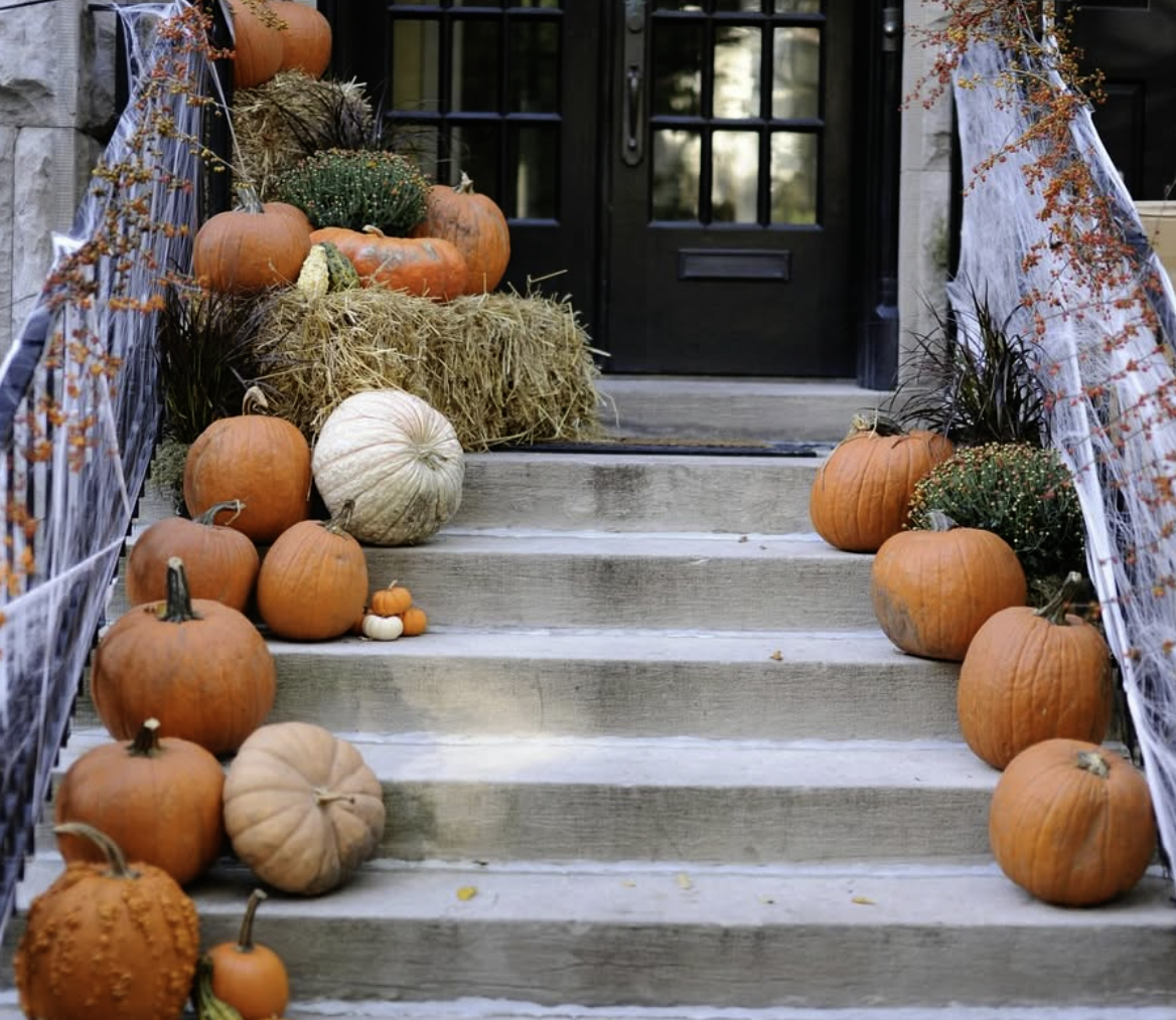 “Rustic fall porch decorated with pumpkins, hay bales, and cobwebs in Comox Valley BC”