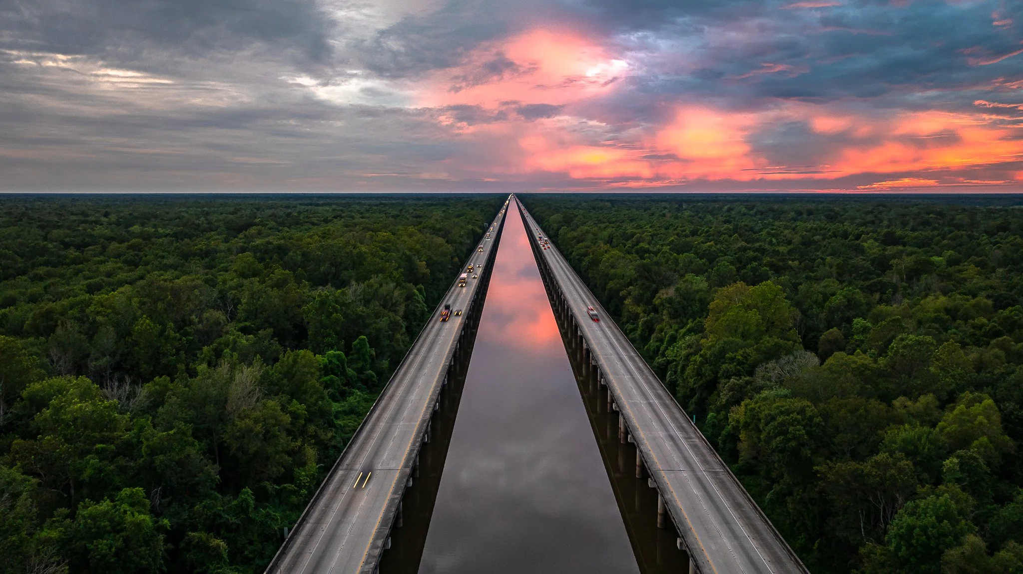 Sunset Aerial View over the Atchafalaya Basin Bridge

A stunning golden-hour drone shot looking directly down the center of the Atchafalaya Basin Bridge on Interstate 10 in Louisiana. The vanishing point of the twin highway structures stretches towar