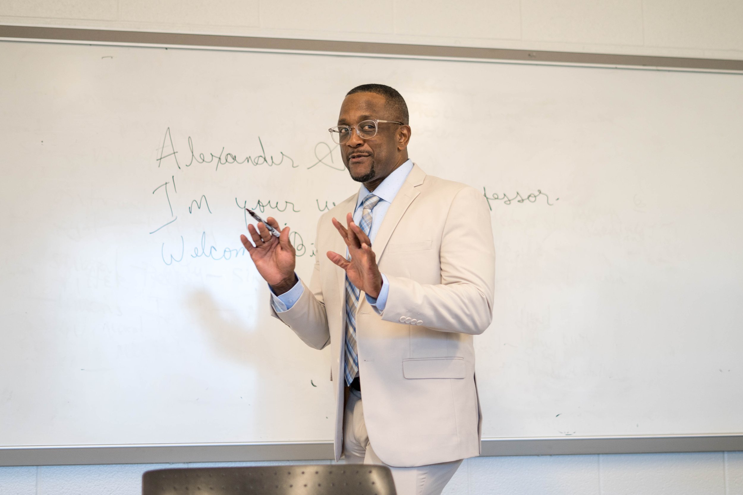 Alexander Scott speaking in a classroom.