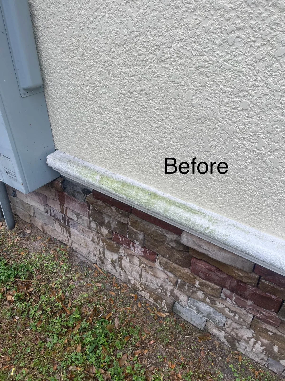 A textured beige exterior wall with a stone foundation and a white painted trim, labeled 'Before'.