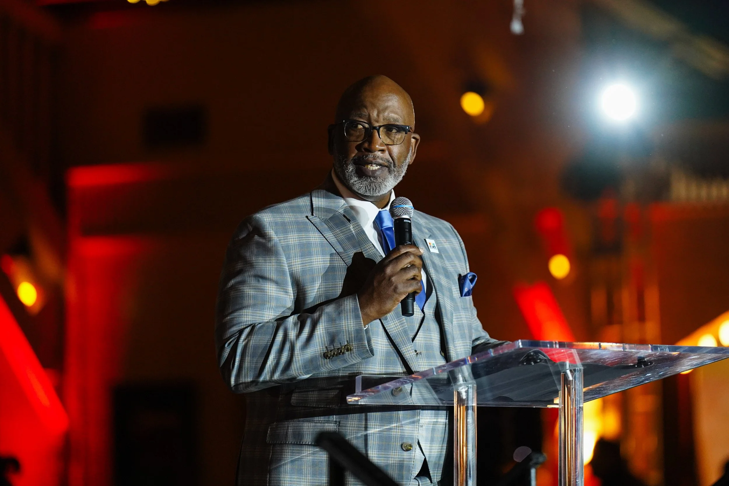 Color swatches or paint samples with Pantone names and codes, fanned out on a white surface next to a glass of water.