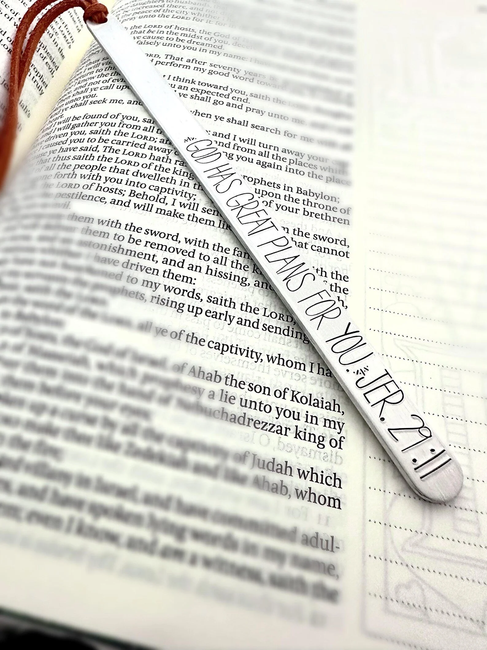 A bookmark with a religious verse placed on an open Bible.