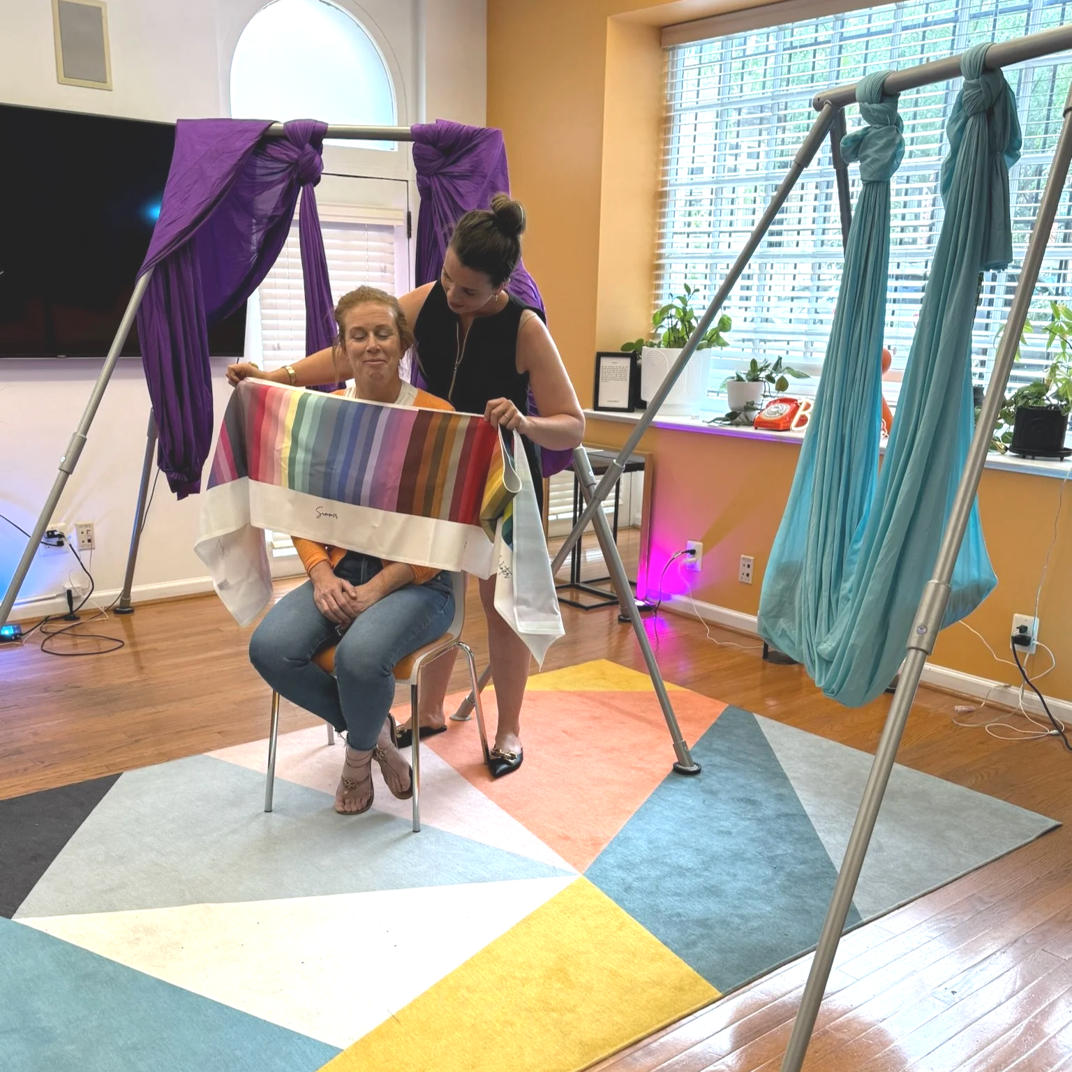 Jenna holding up a color swatch cloth below the face of a corporate color consultation client