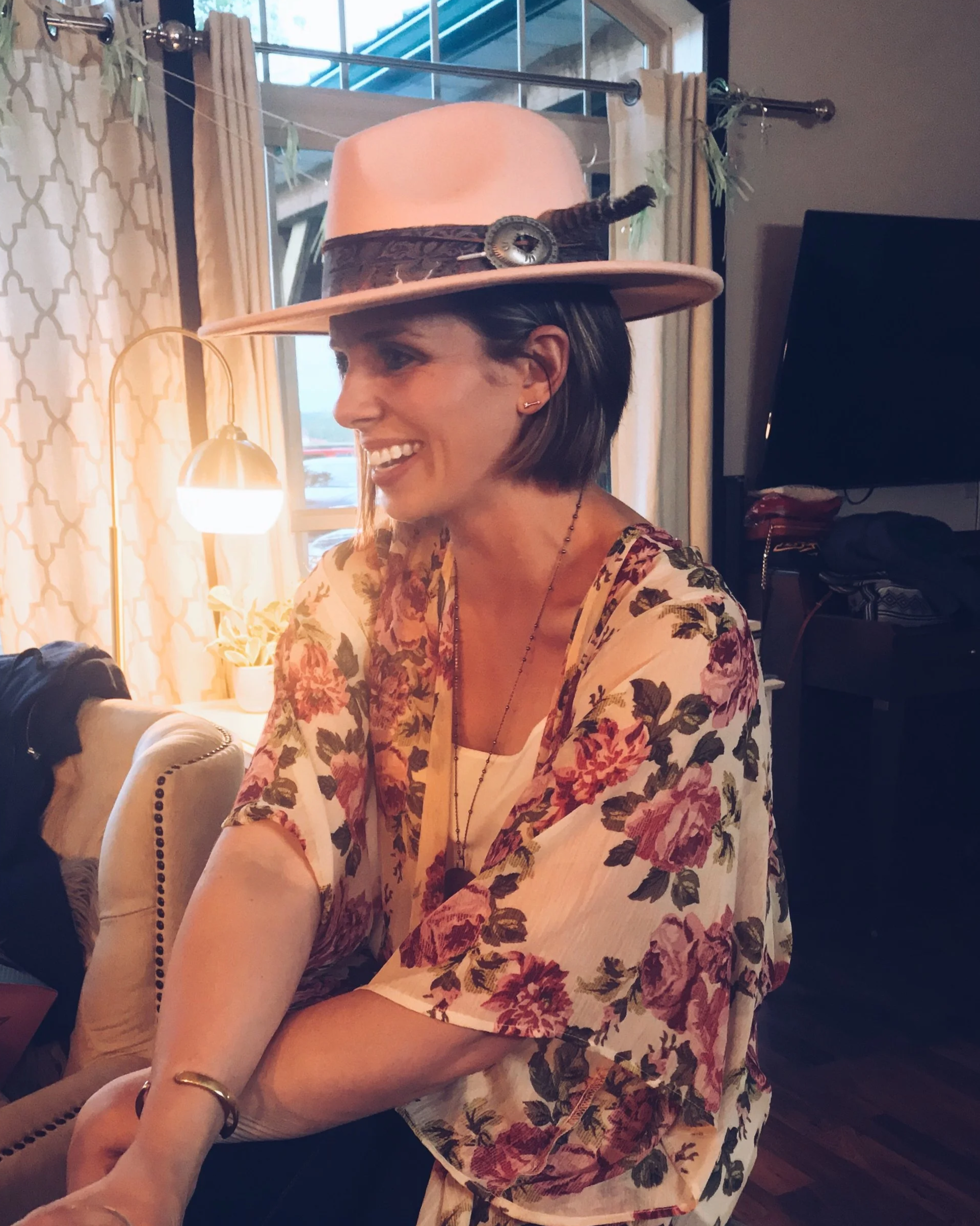 Jenna Matthews in profile, wearing a hat and blouse with pink roses