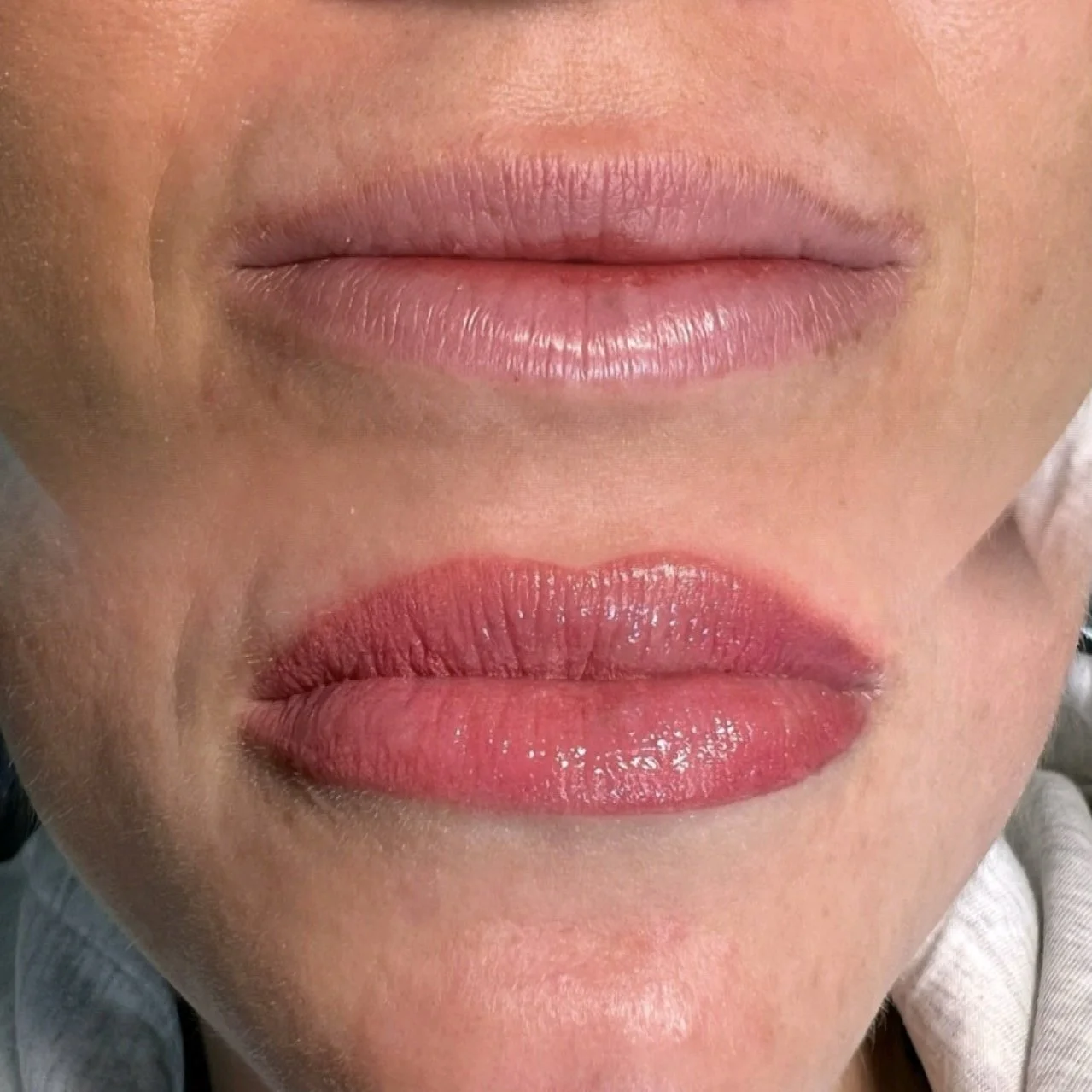 Close-up of a person's lips before and after applying lipstick, showing natural lips above and glossy pink lipstick on below.