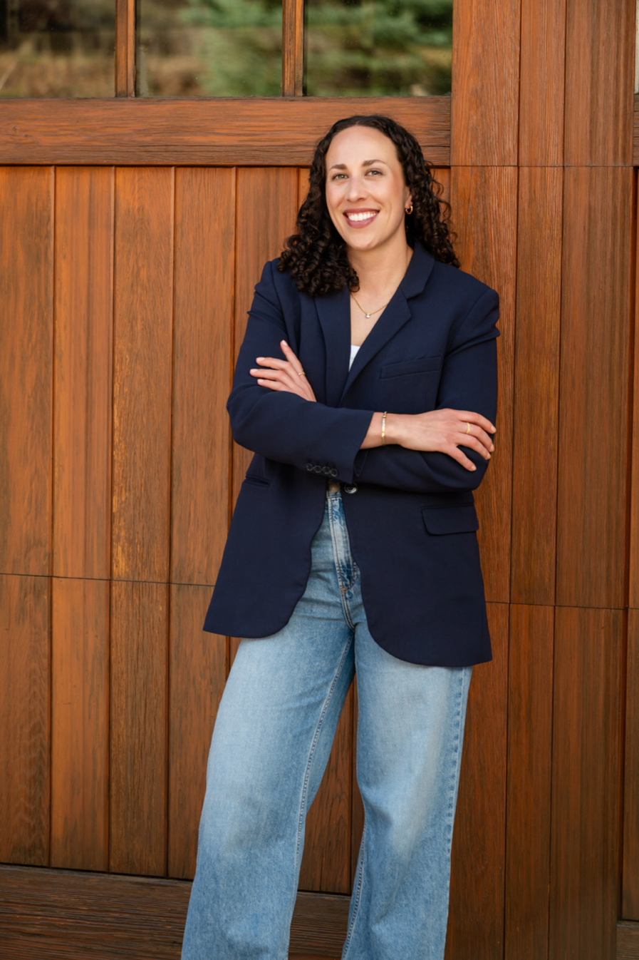 Natalie Youssef, health and performance coach and founder of Thrive With You, smiling with arms crossed in a navy blazer