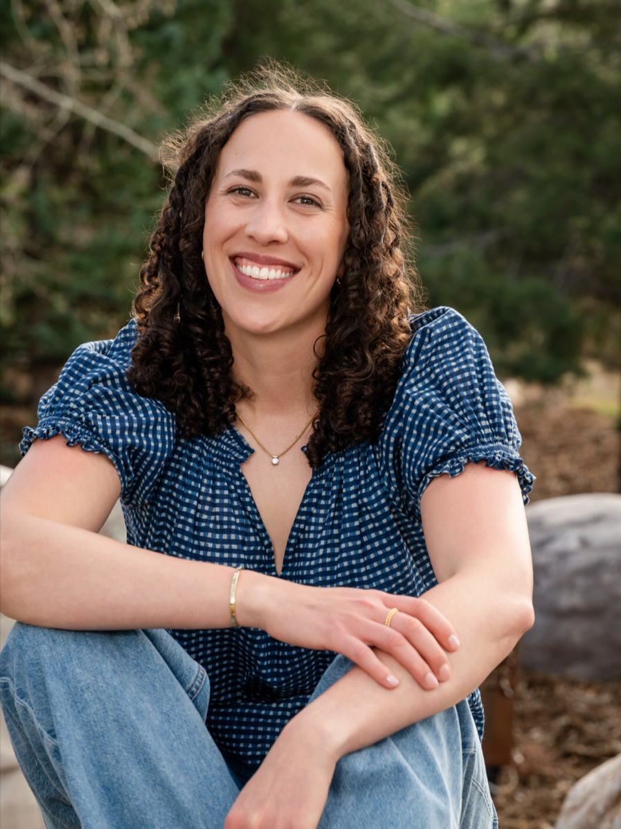 Natalie Youssef, health coach and MPH, smiling outdoors in a relaxed natural setting